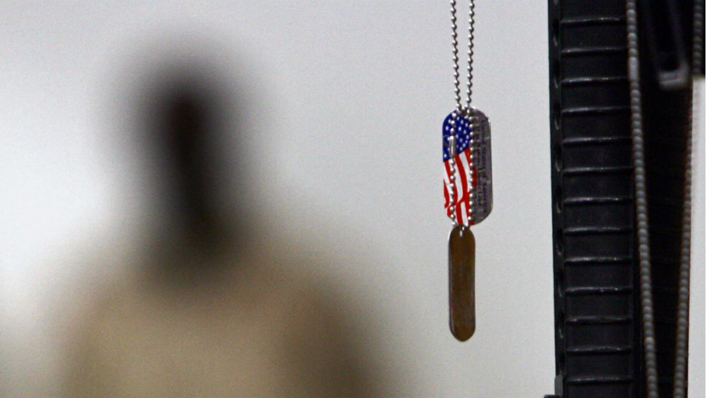 A US dogtag hangs next to an M16 rife