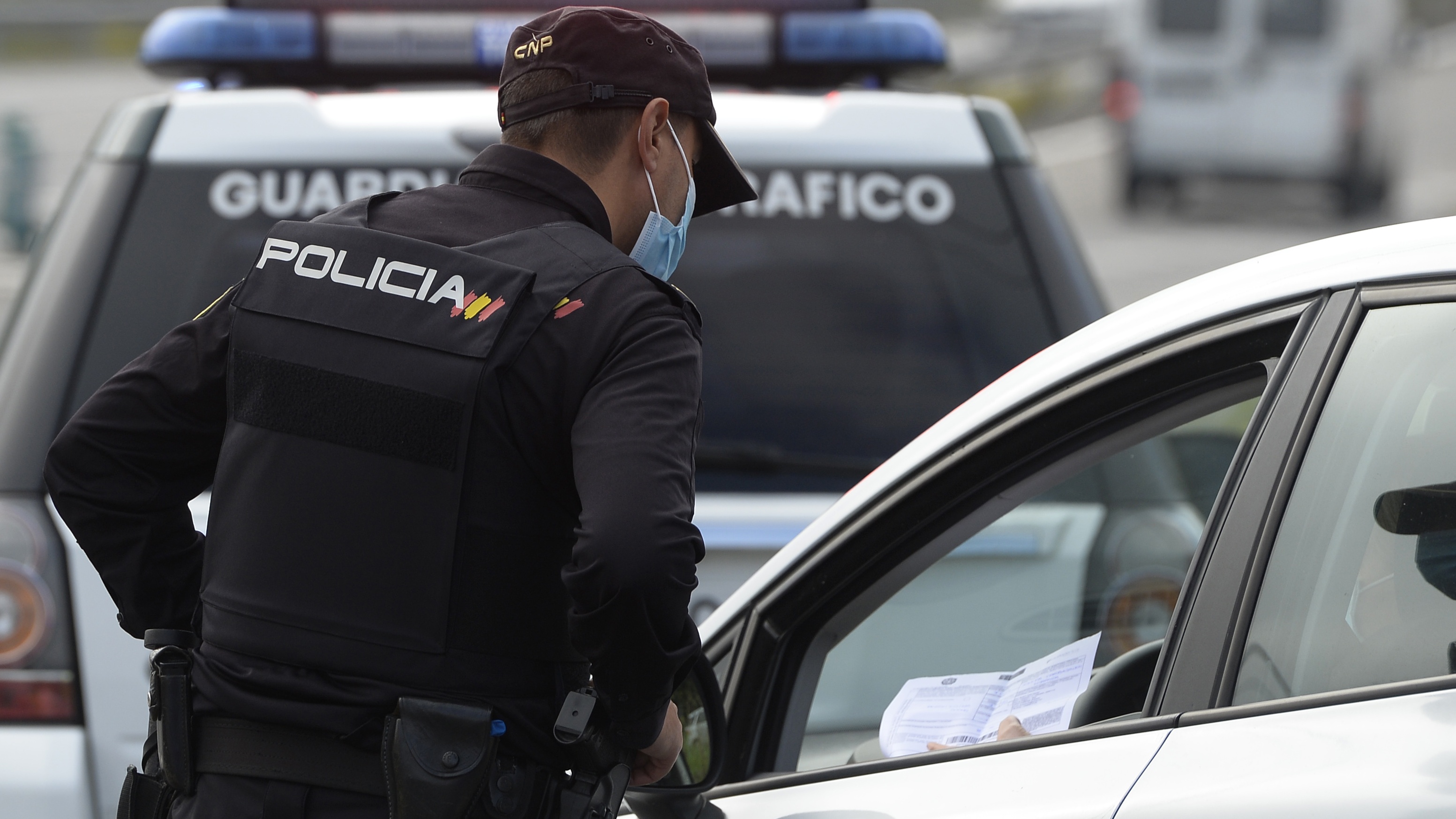 A spanish police officer controls cars at a traffic checkpoint