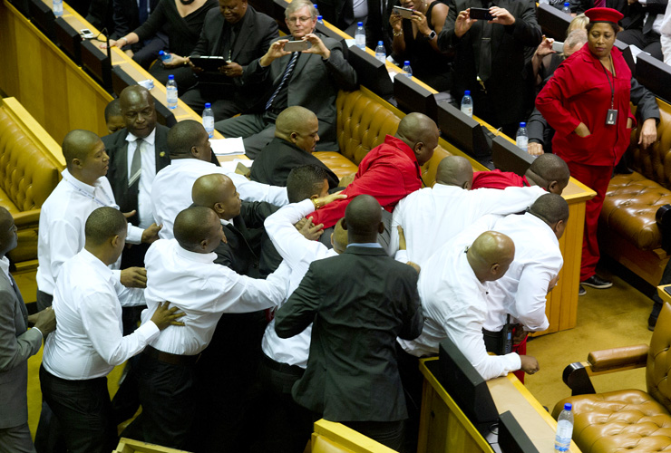 Members of the Economic Freedom Fighters, wearing red uniforms, clash with security forces during South African President&#039;s State of the Nation address in Cape Town on February 12, 2015. Secu