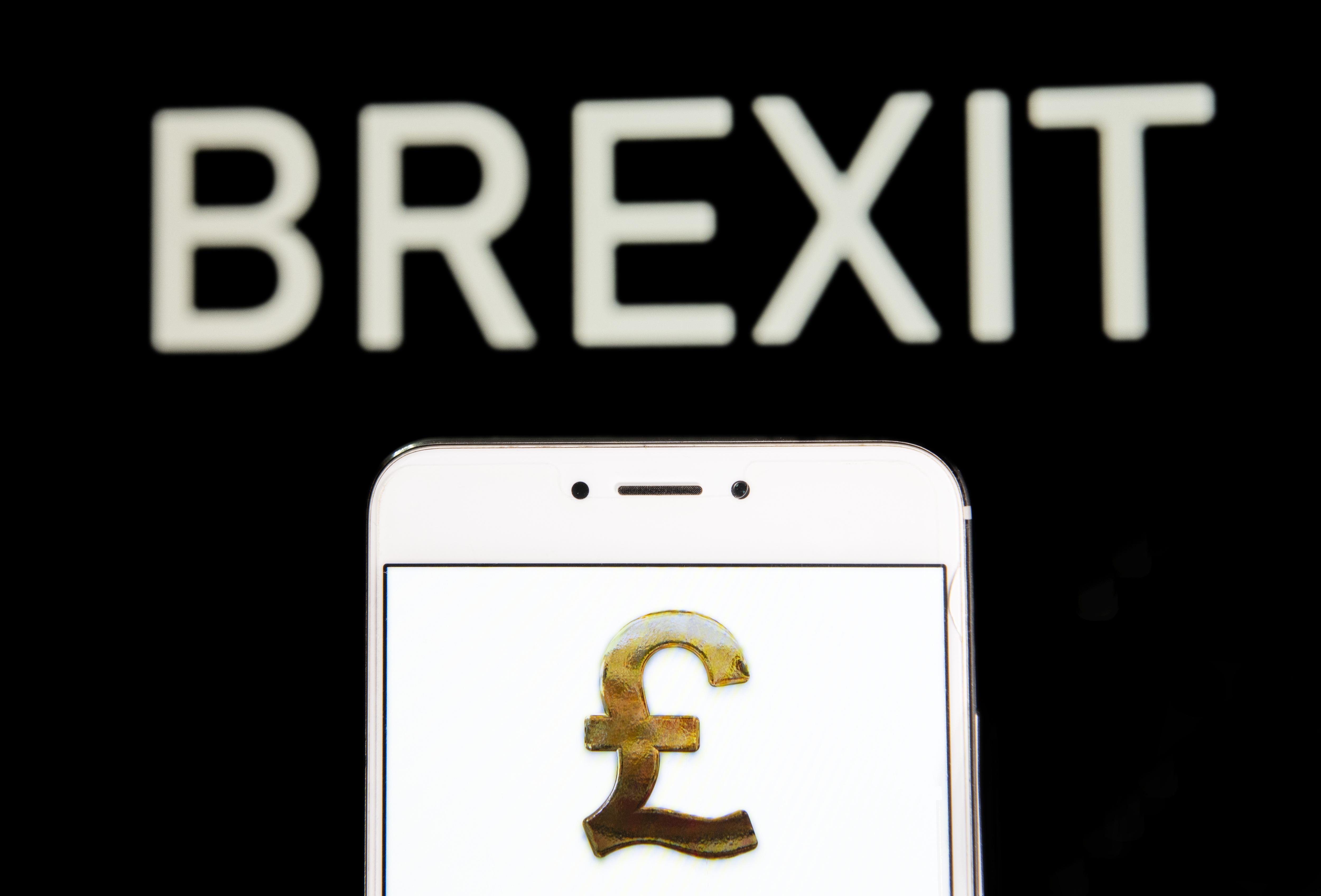 HONG KONG - 2019/04/20: In this photo illustration a Great Britain&#039;s currency Pound Sterling icon is seen on an Android mobile device with a Brexit message in the background. (Photo Illustrat