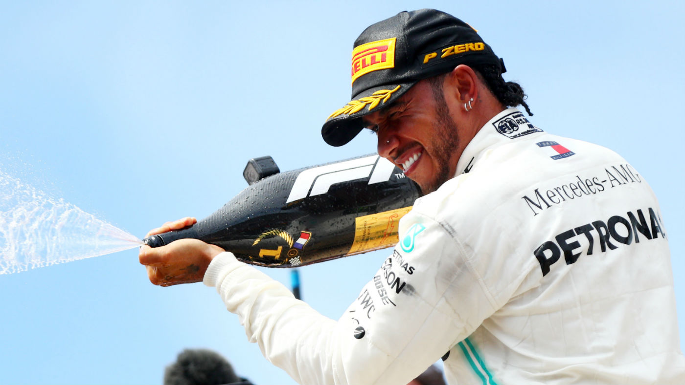 Mercedes driver Lewis Hamilton celebrates on the podium after his win at the French GP