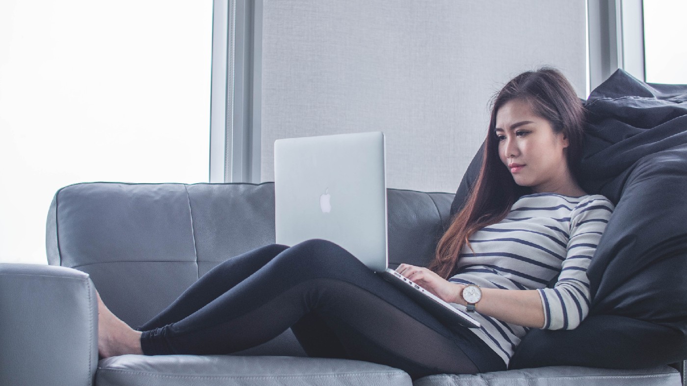 Remote worker sitting on sofa with her laptop