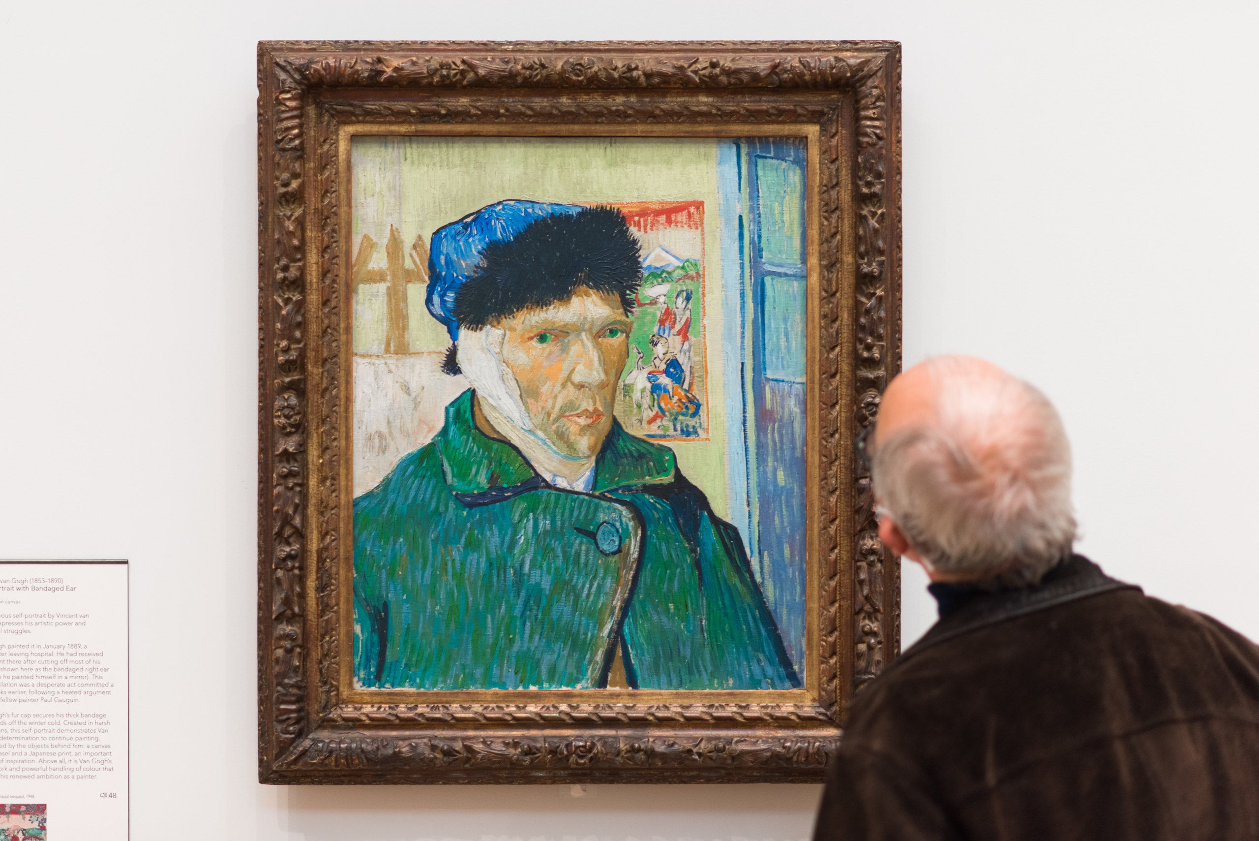 Man looking at Van Gogh self-portrait 