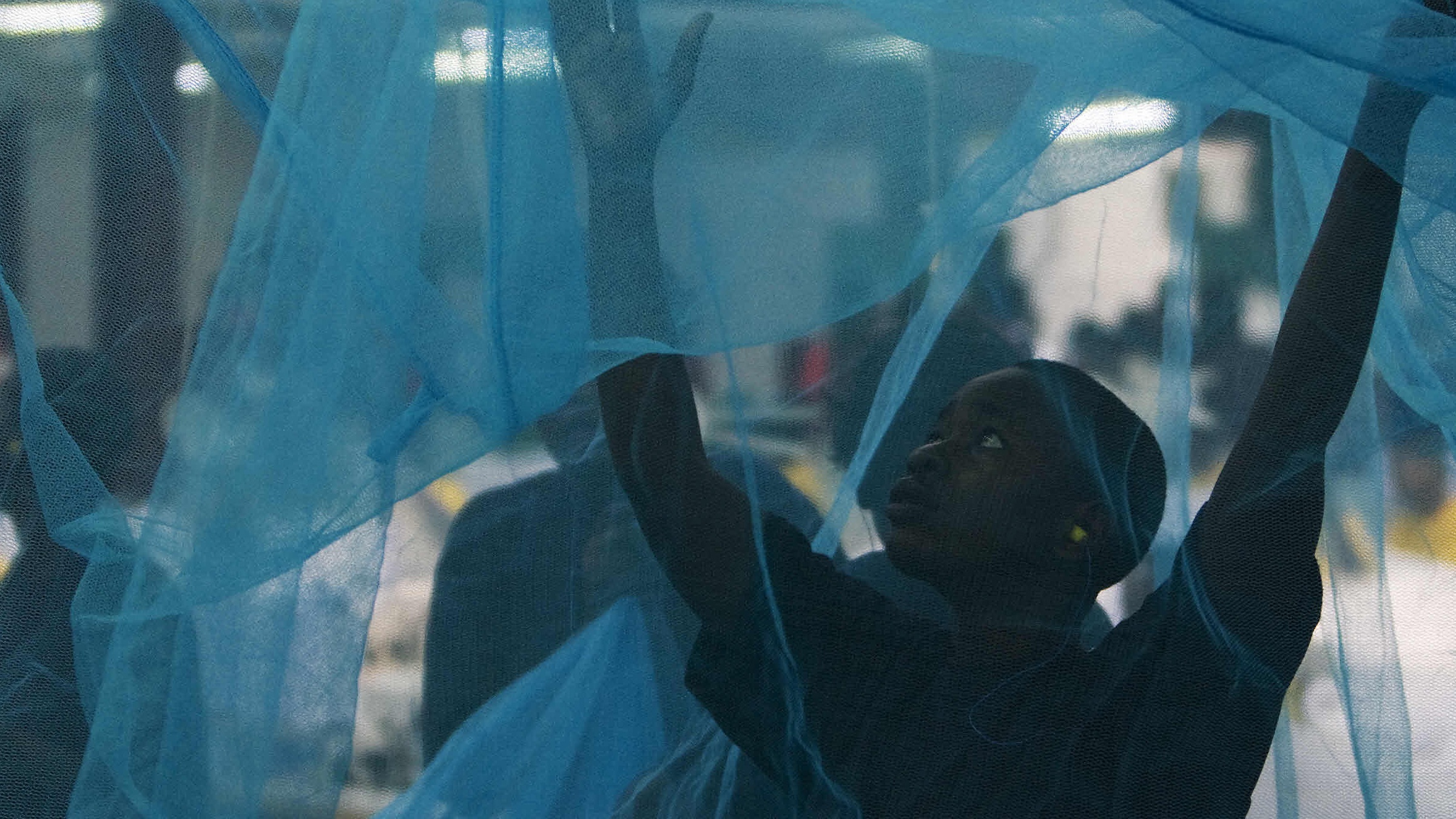 A worker inspects a mosquito net in Arusha, Tanzania