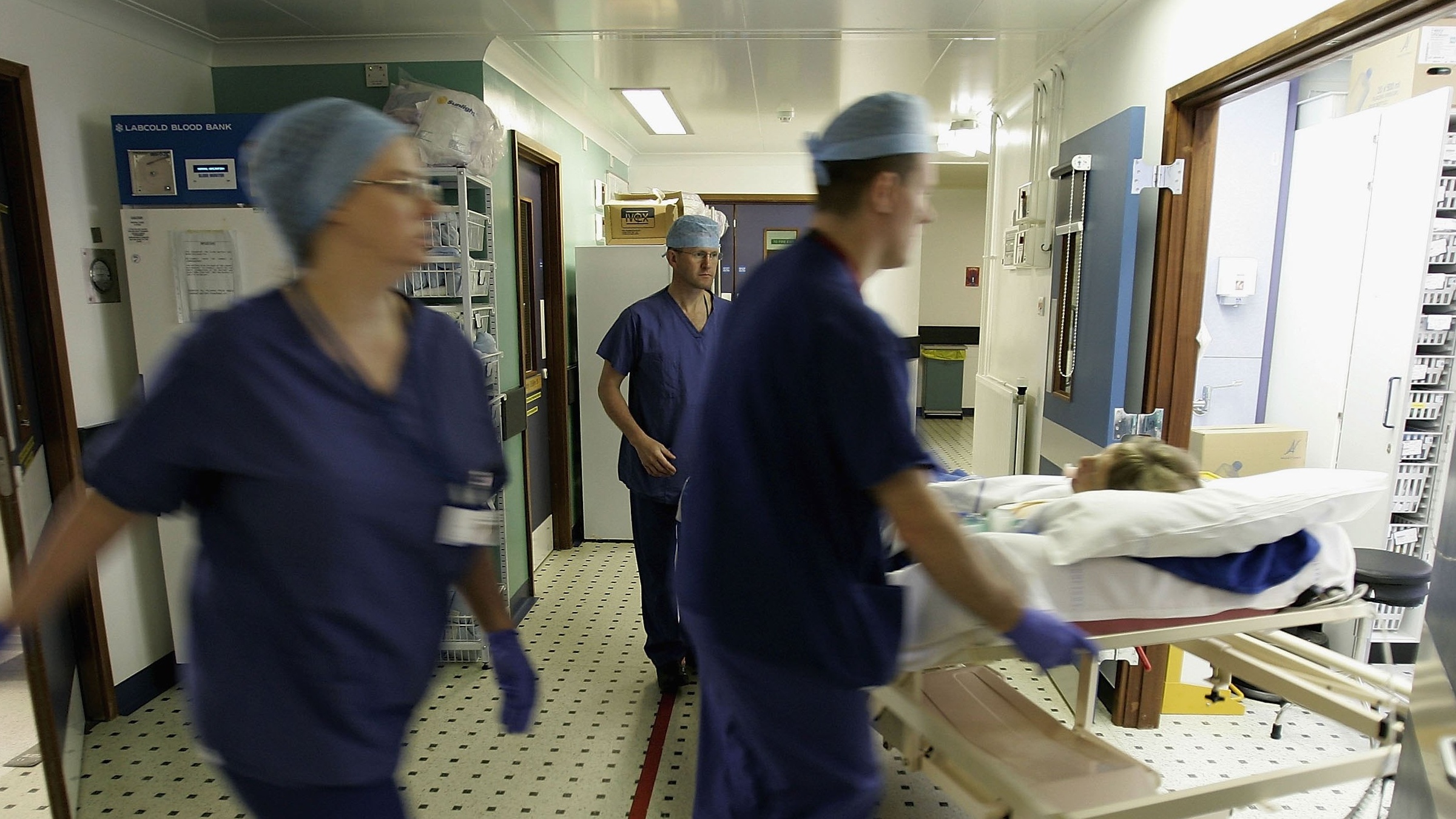 NHS nurses transport a patient out of surgery.