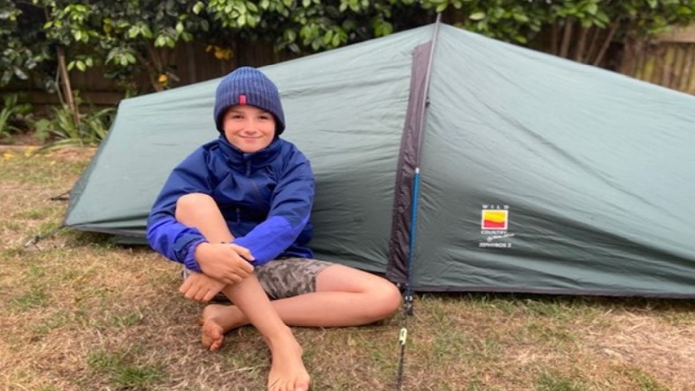 Max smmiling in front of his tent