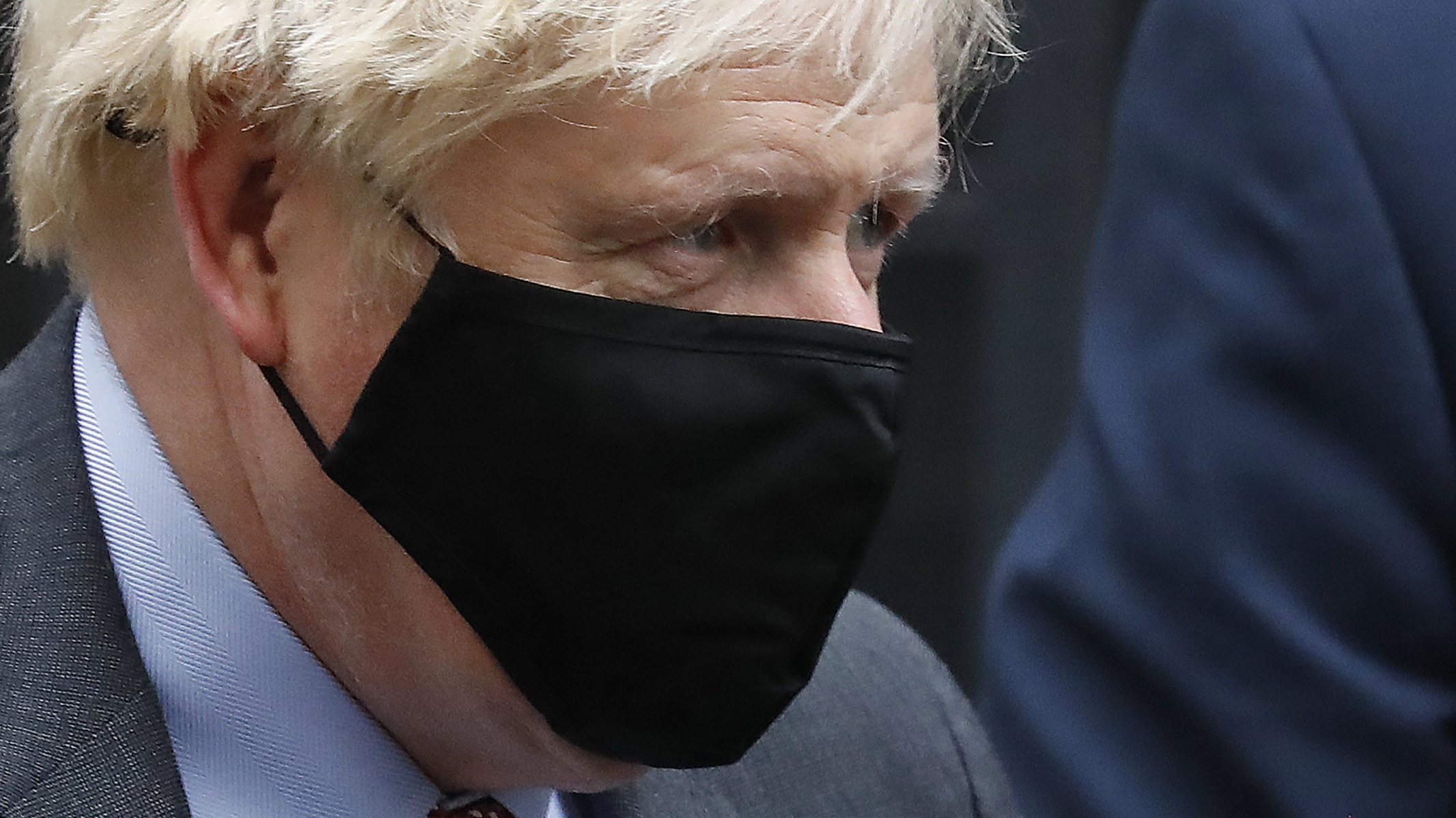 Boris Johnson leaves Downing Street wearing a face mask.