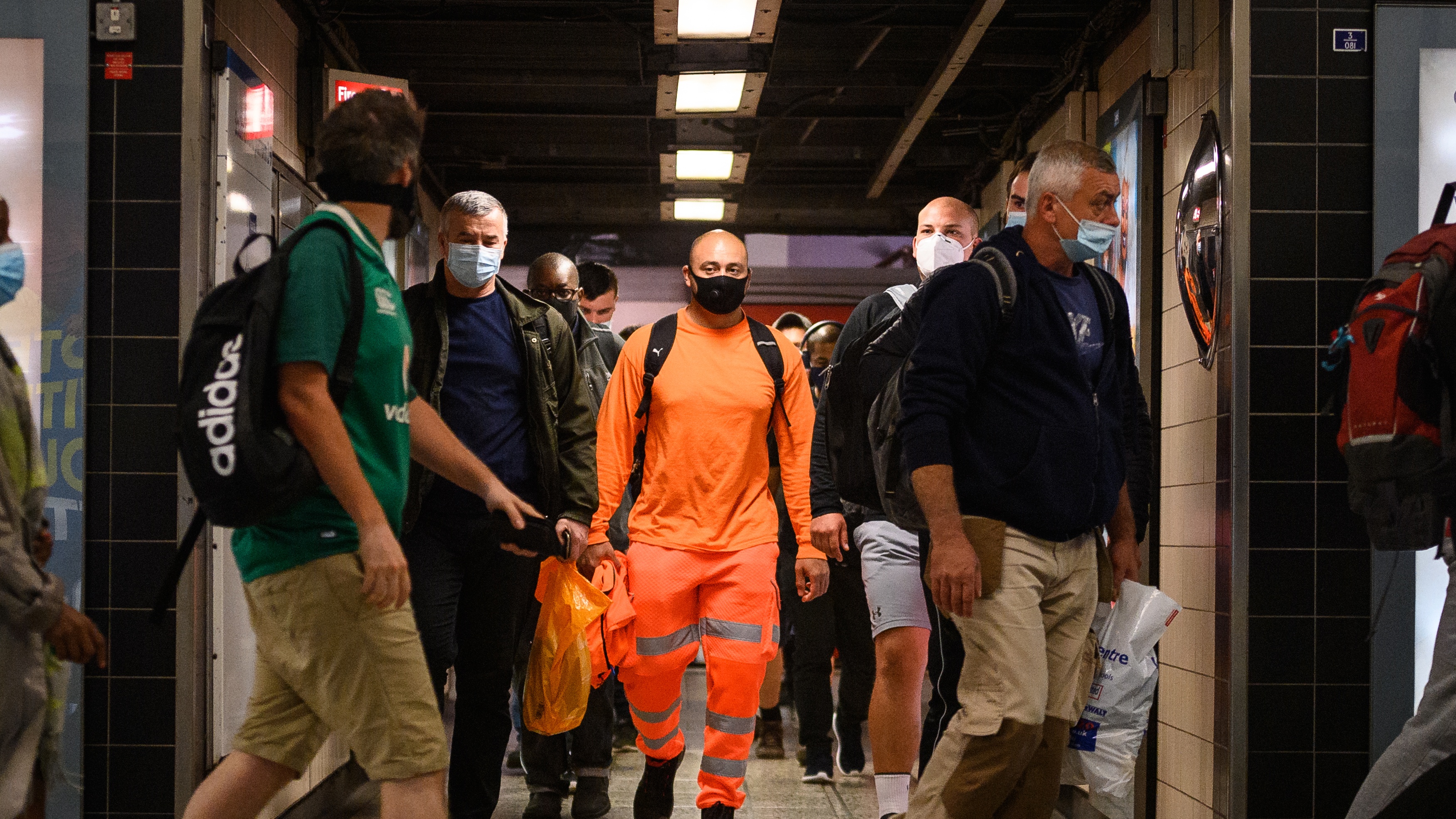 Commuters wear face masks as they pass through Vauxhall underground station, London.