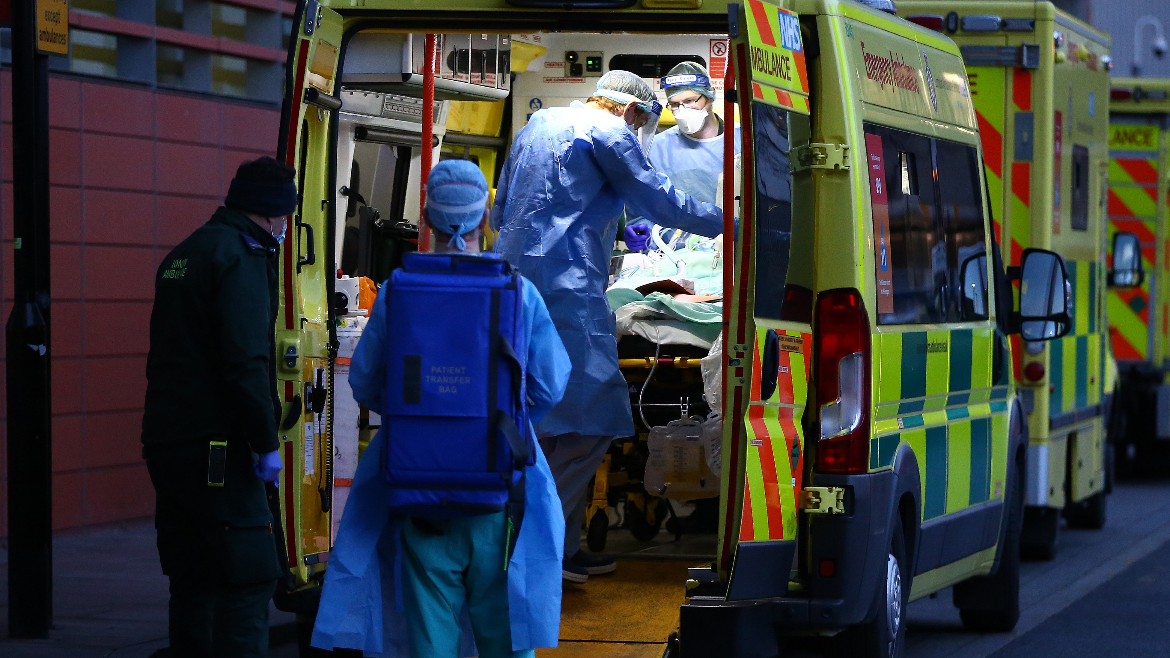 A patient is transported out of an ambulance by medics wearing PPE at the Royal London Hospital.