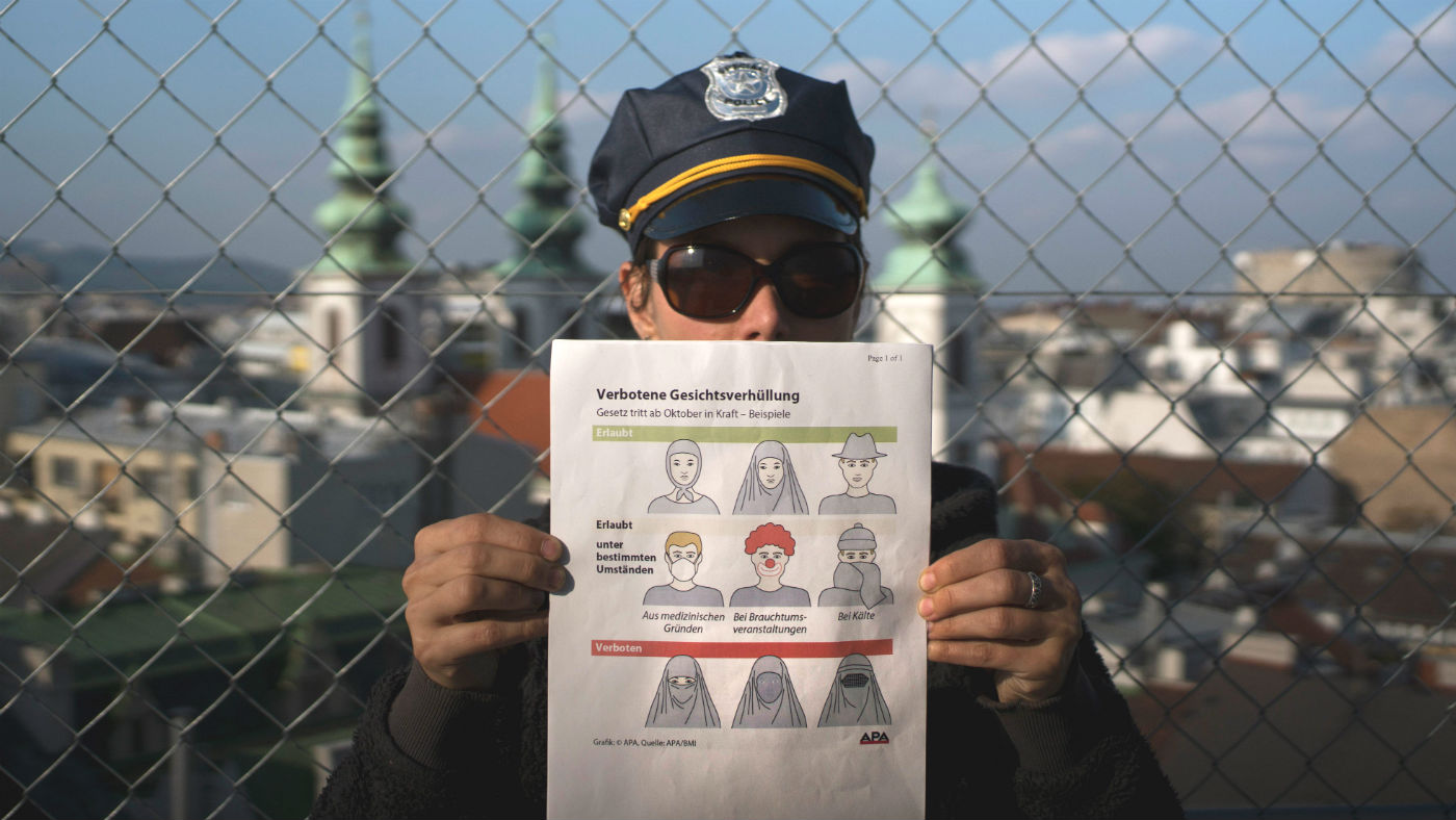 An Austrian policeman holds up a pamphlet setting out the new restrictions