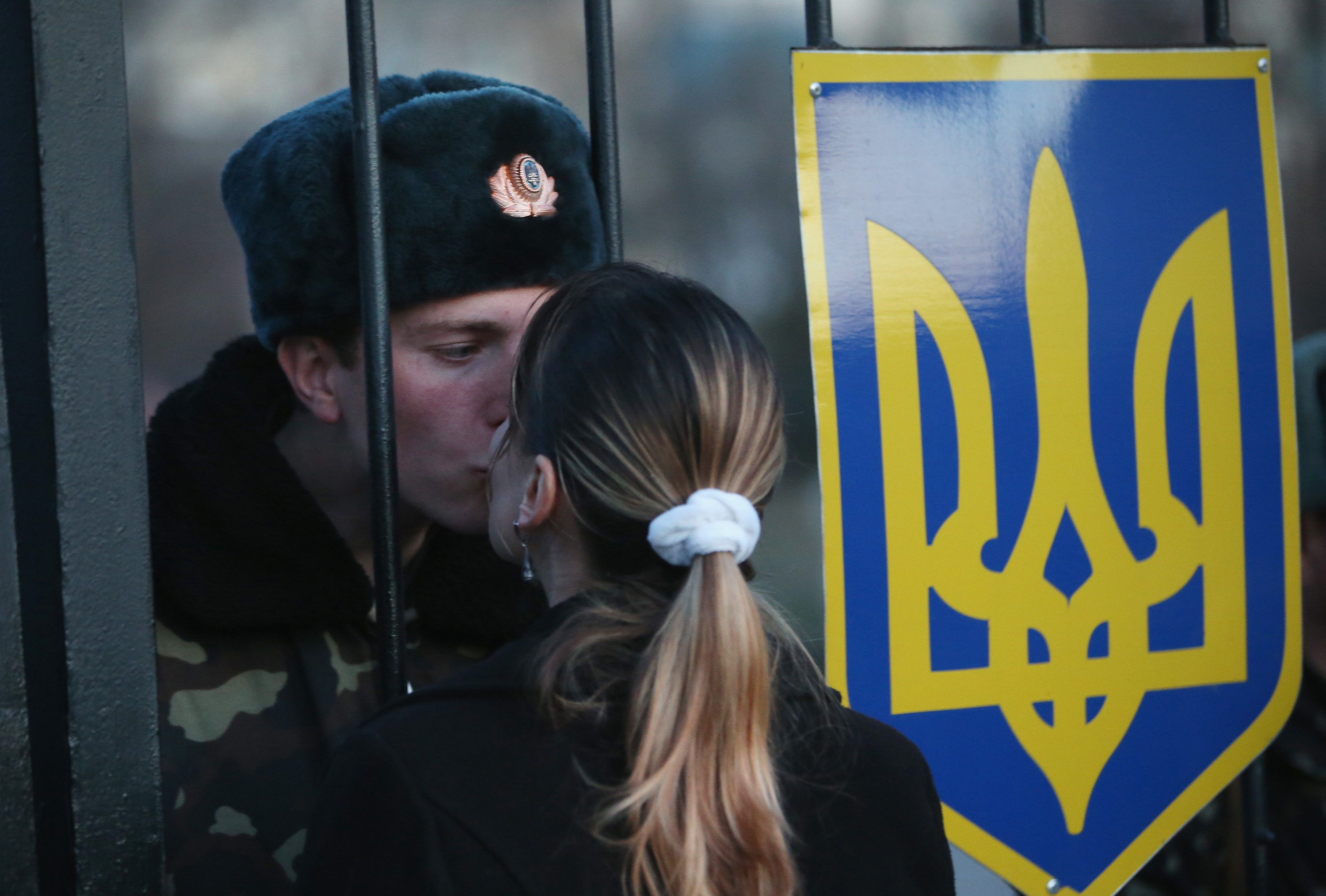 LUBIMOVKA, UKRAINE - MARCH 03:Oleg, a Ukrainian soldier at the Belbek military base, kisses his girlfriend Svetlana through the gates of the base entrance on March 3, 2014 in Lubimovka, Ukrai