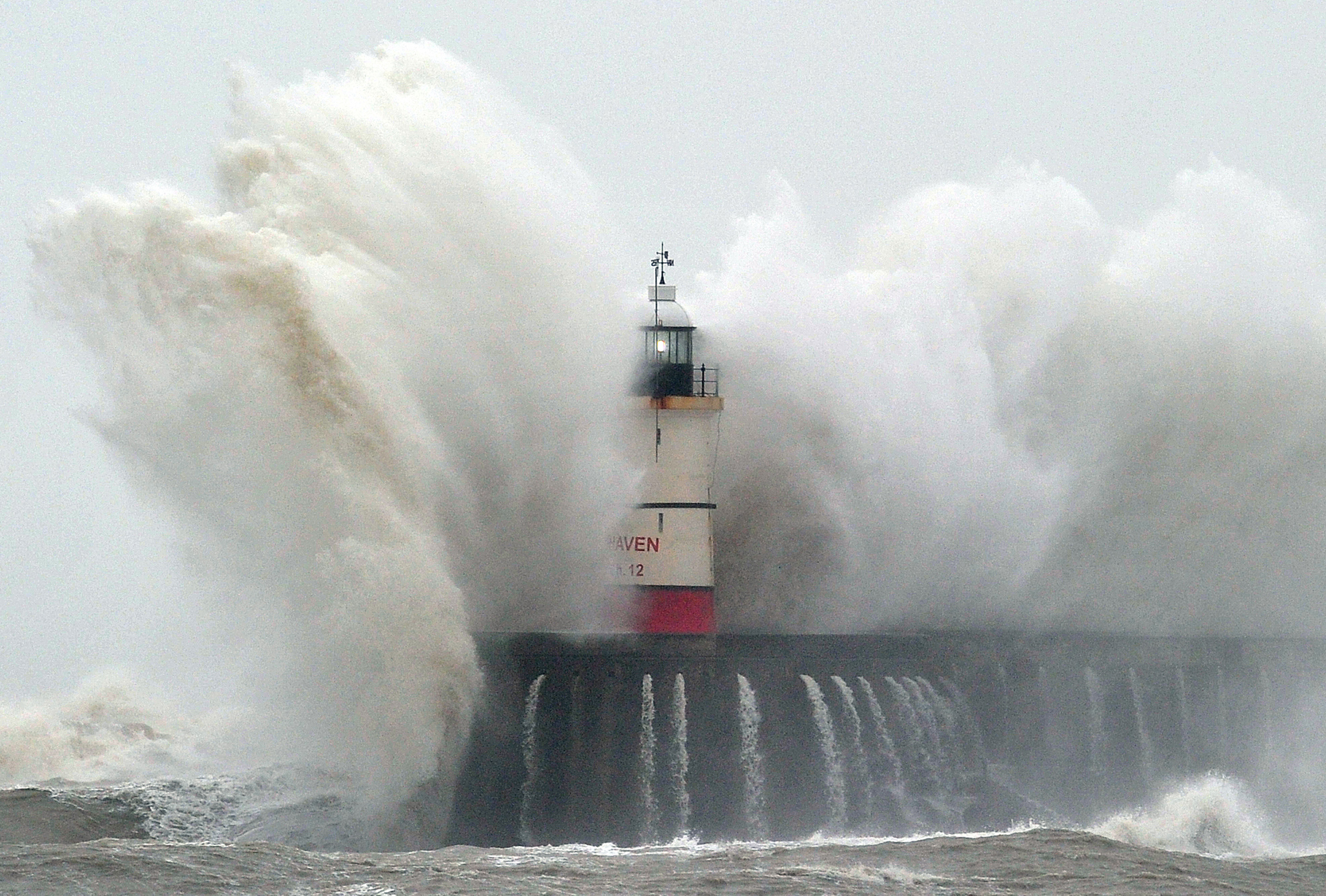 Newhaven Lighthouse is battered by waves during stormy weather in Newhaven on the southern coast of England on February 5, 2014. More than 8,000 homes were without power in southwest England 