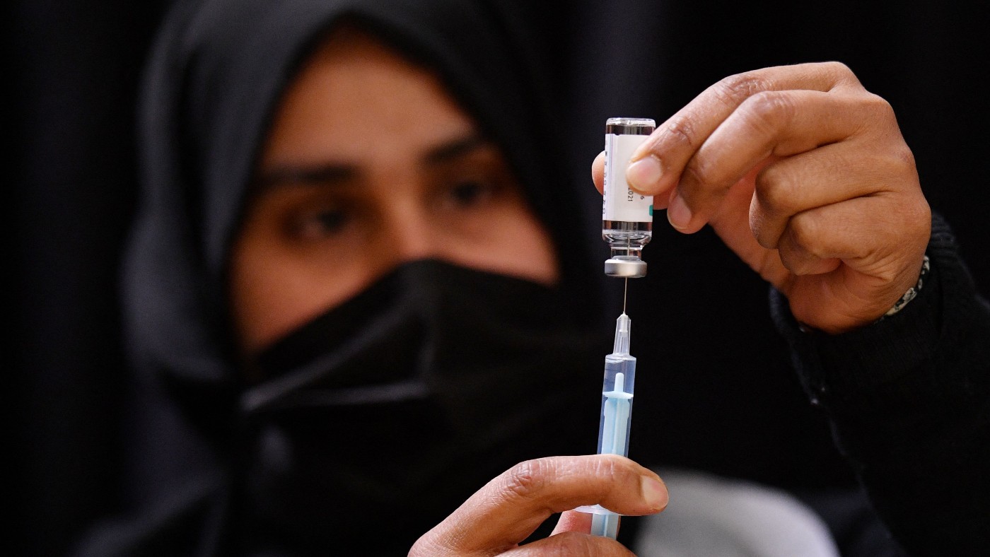 A health worker prepares a vaccine injection