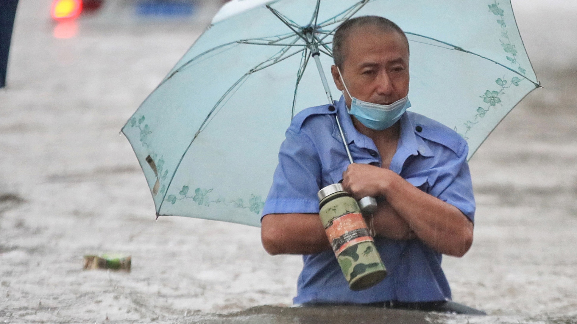 A man wades through flood water in Zhengzhou, Henan province