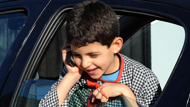 A young boy talks on his mobile phone