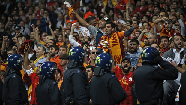 Police watch over Galatasaray supporters during the match between Arsenal and Galatasaray