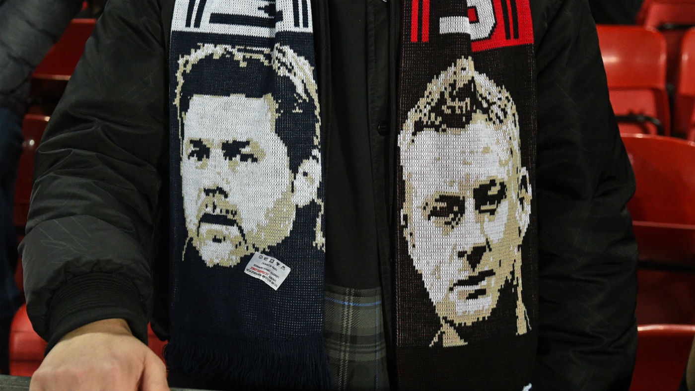 A supporter wears a scarf showing ex-Tottenham boss Mauricio Pochettino and Manchester United manager Ole Gunnar Solskjaer