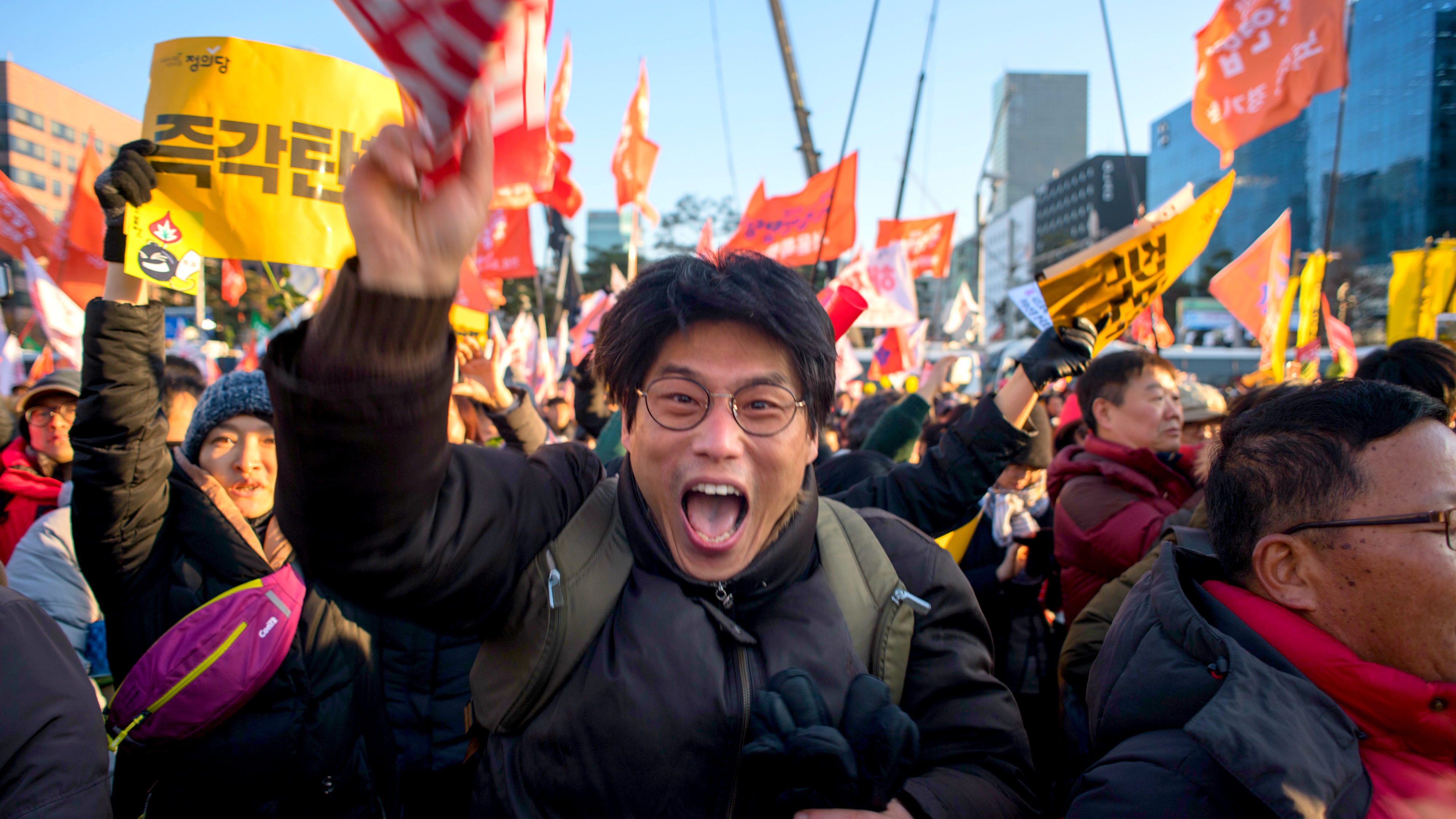 Activists outside the National Assembly in Seoul, South Korea celebrate the impeachment of President Park Geun-hye 