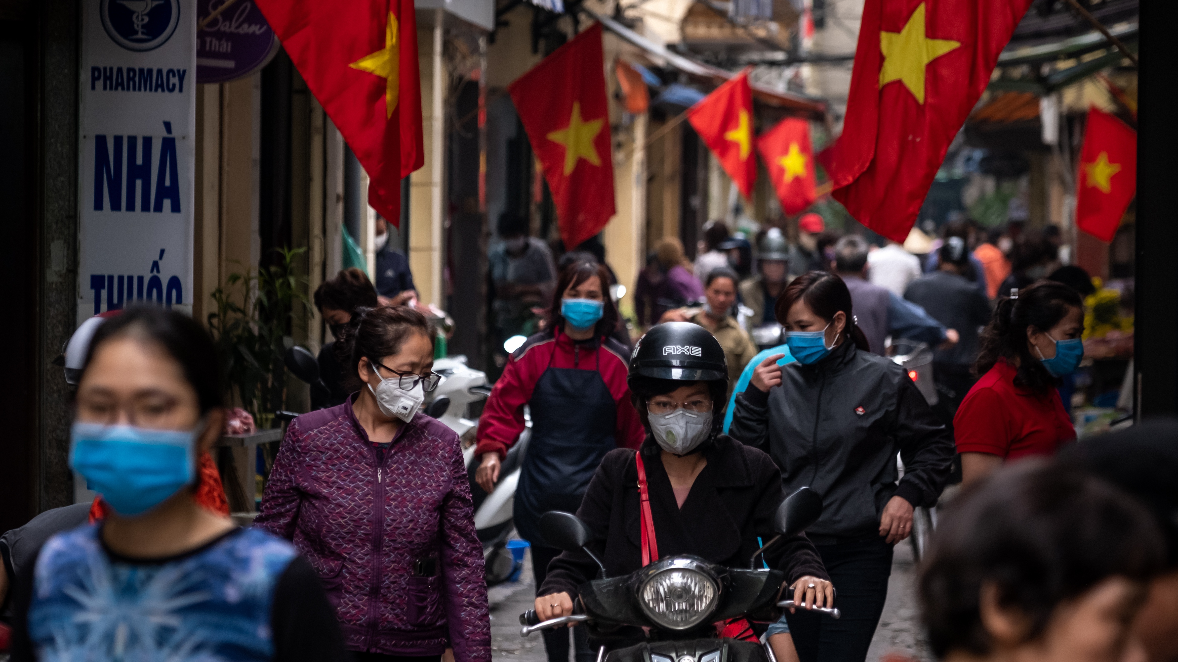 People wear face masks while shopping in Hanoi
