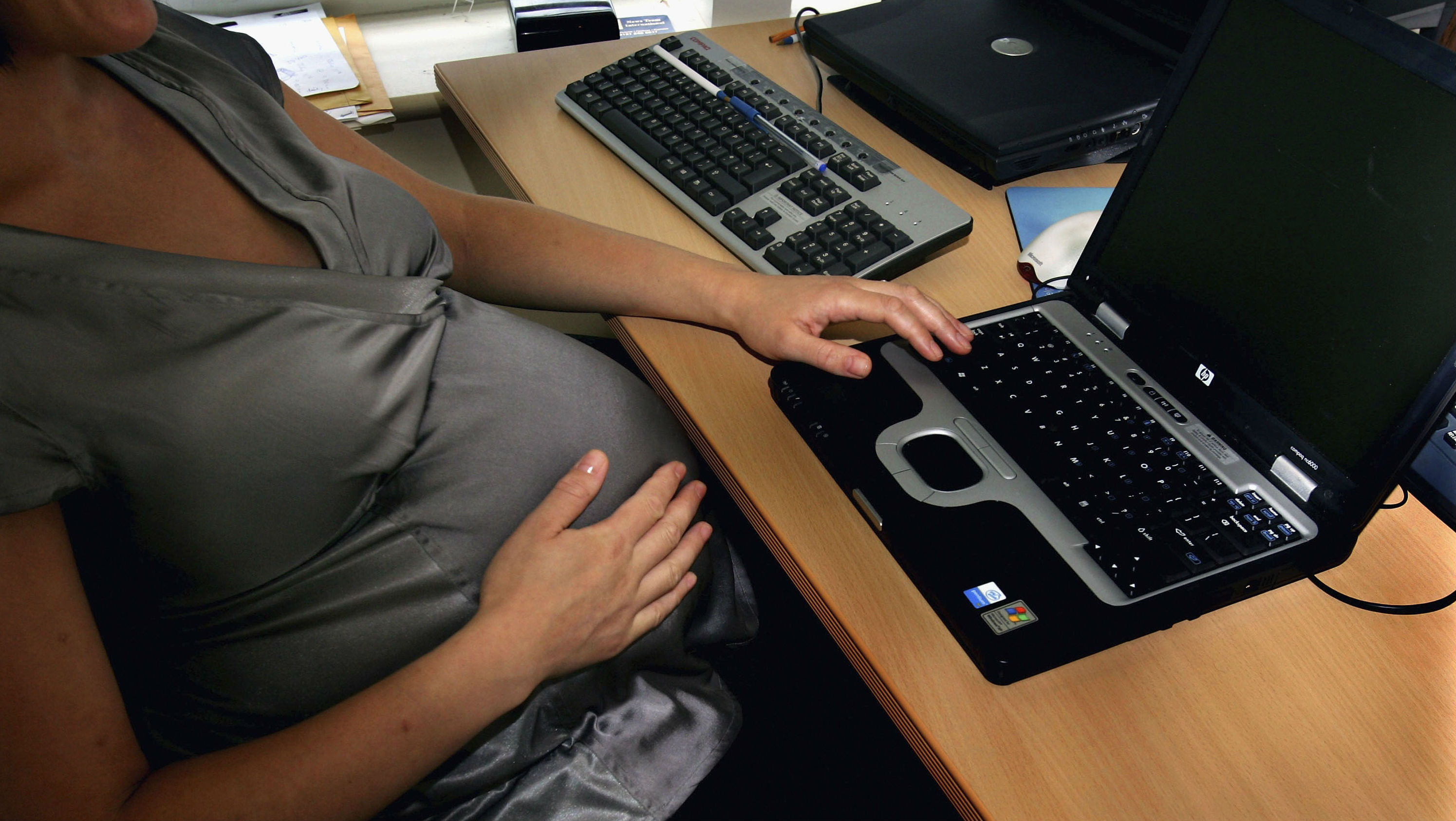 A pregnant woman is seen at the office work station on July 18, 2005 in London, England.