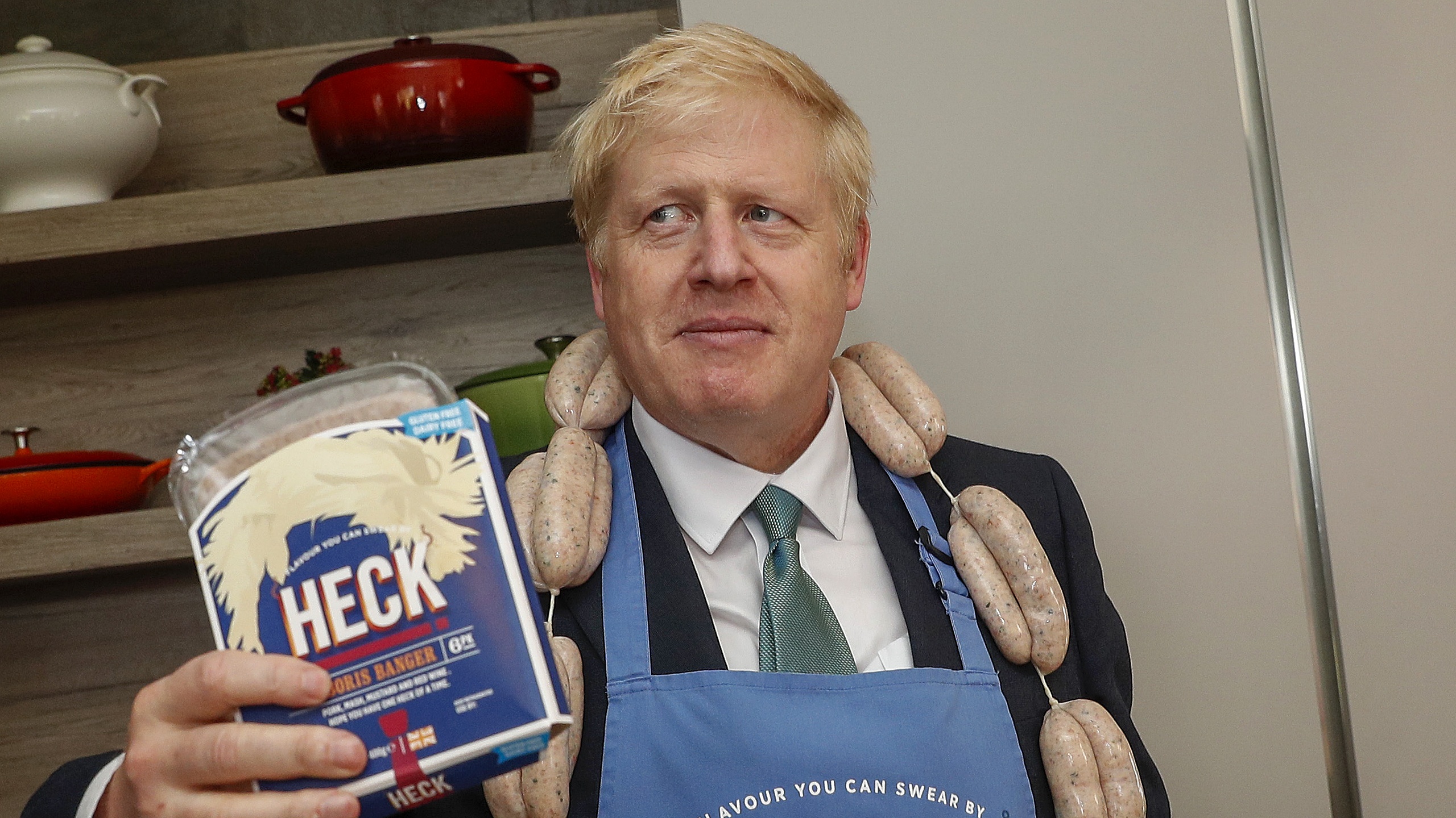 Boris Johnson poses with a string of sausages called &quot;Boris Bangers&quot; during a visit to Heck Foods.