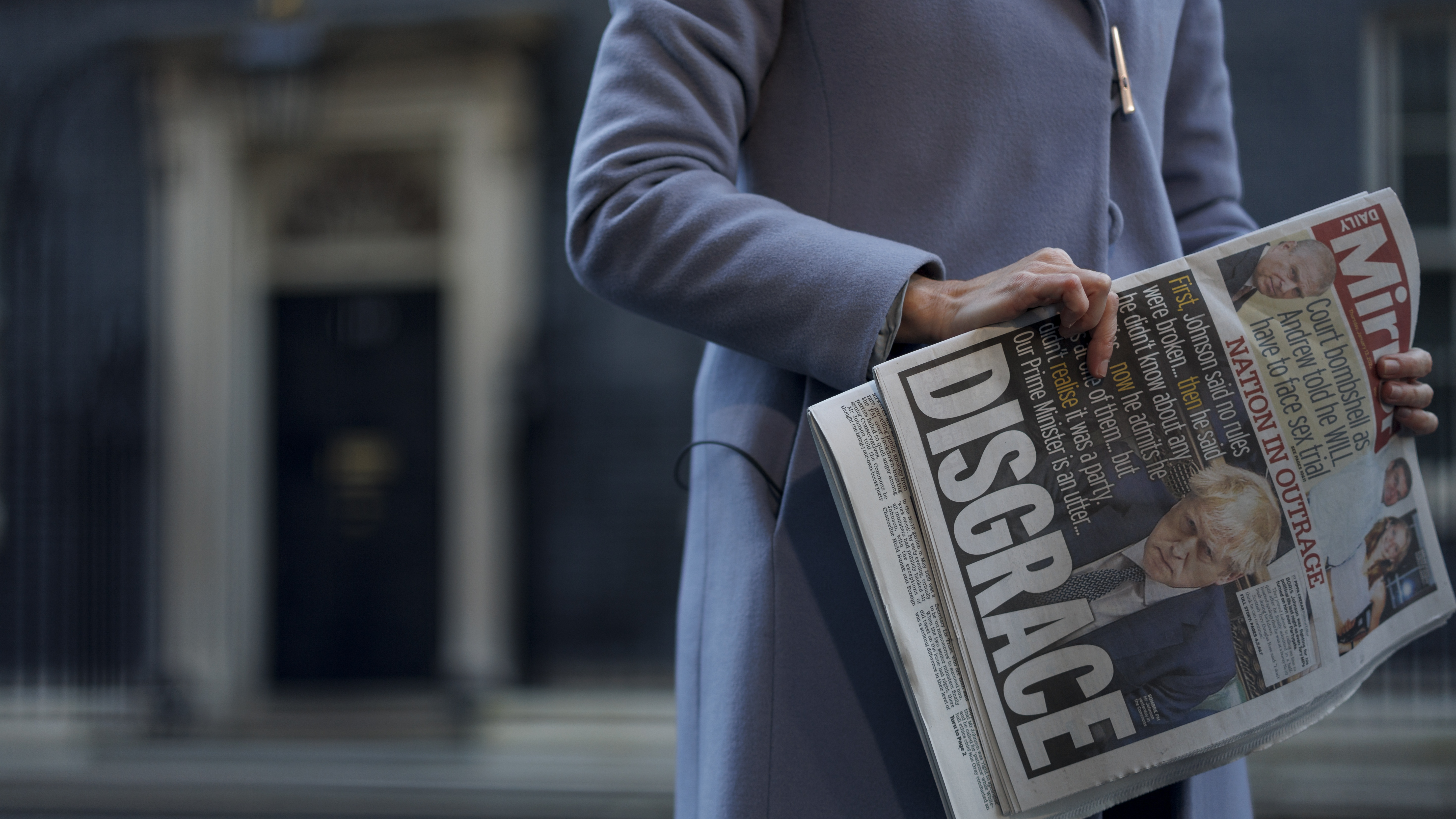 A TV reporter holds the Daily Mirror outside 10 Downing Street