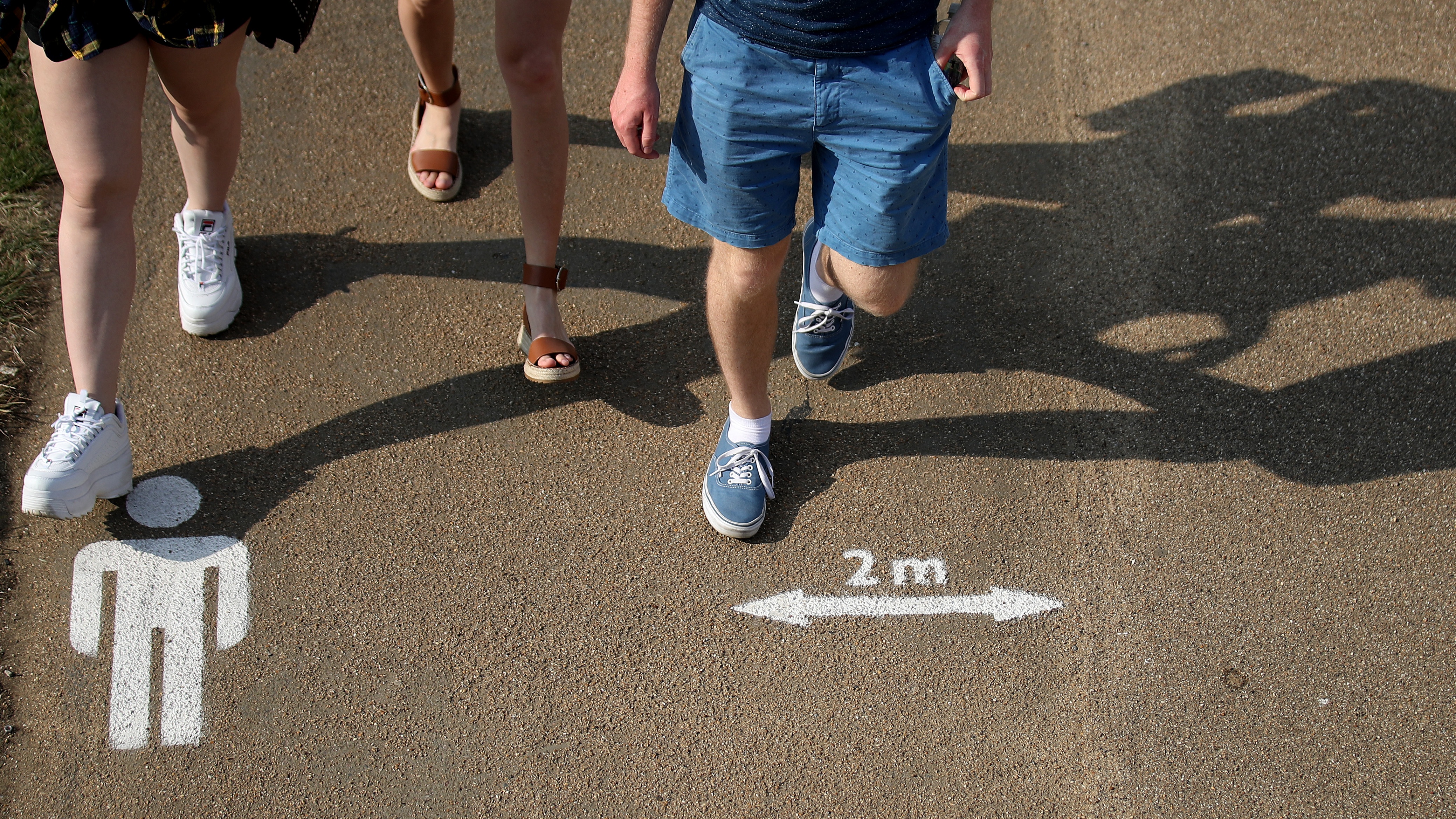 People walk past the social distancing markings on the ground at Queen Elizabeth Olympic Park.