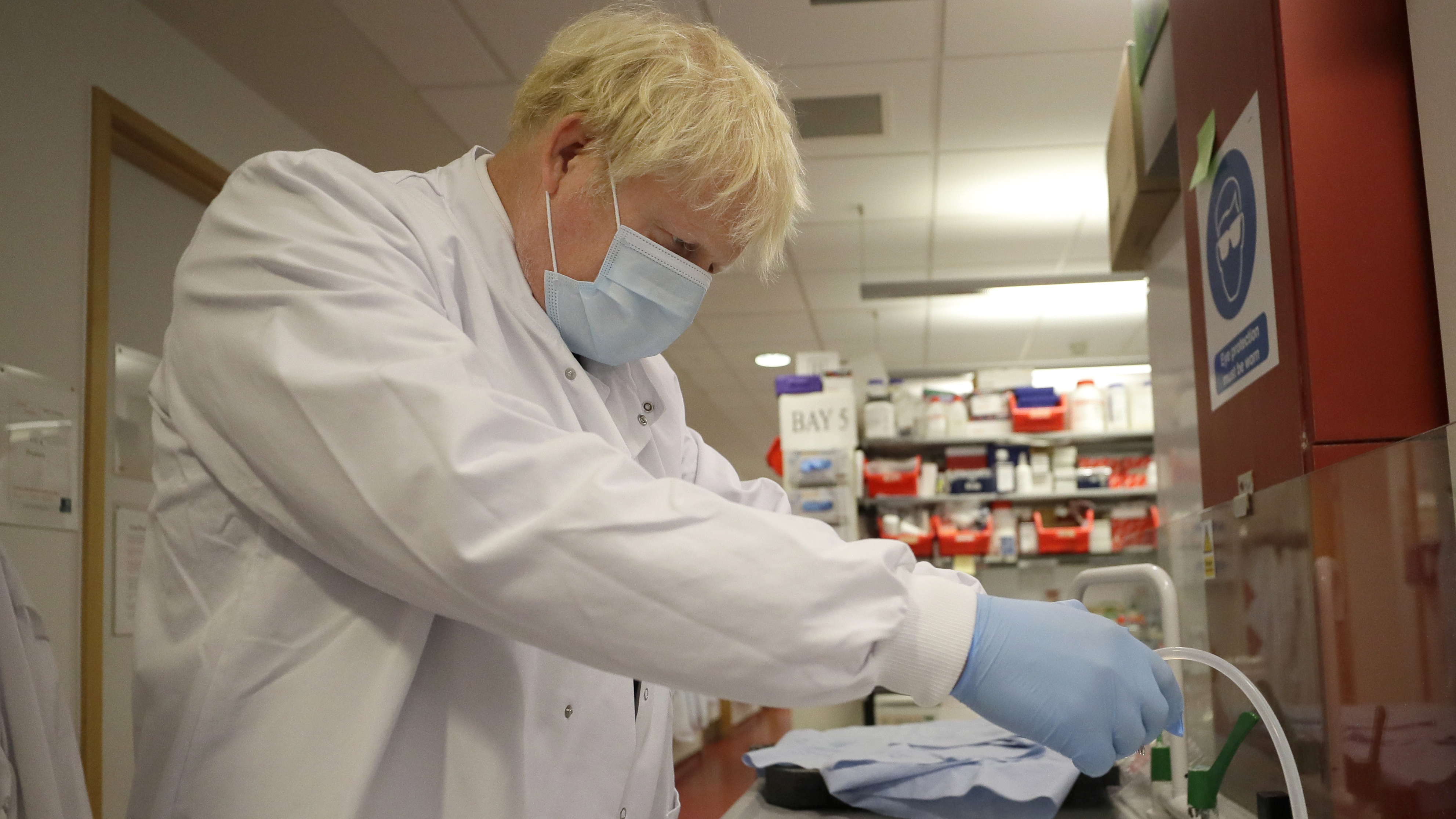Boris Johnson washes immunological assays during a visit to the Jenner Institute.