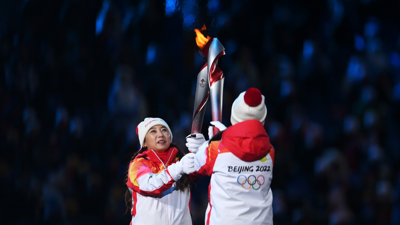 Torch bearers carry the Olympic flame during the Opening Ceremony of the Beijing 2022 Winter Olympics 
