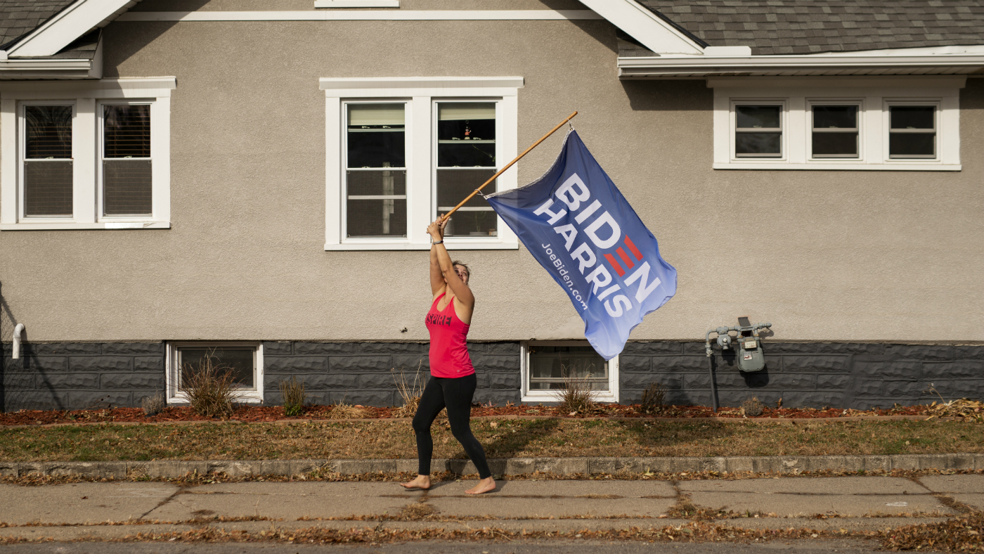 A Joe Biden supporter waves a flag outside her home.
