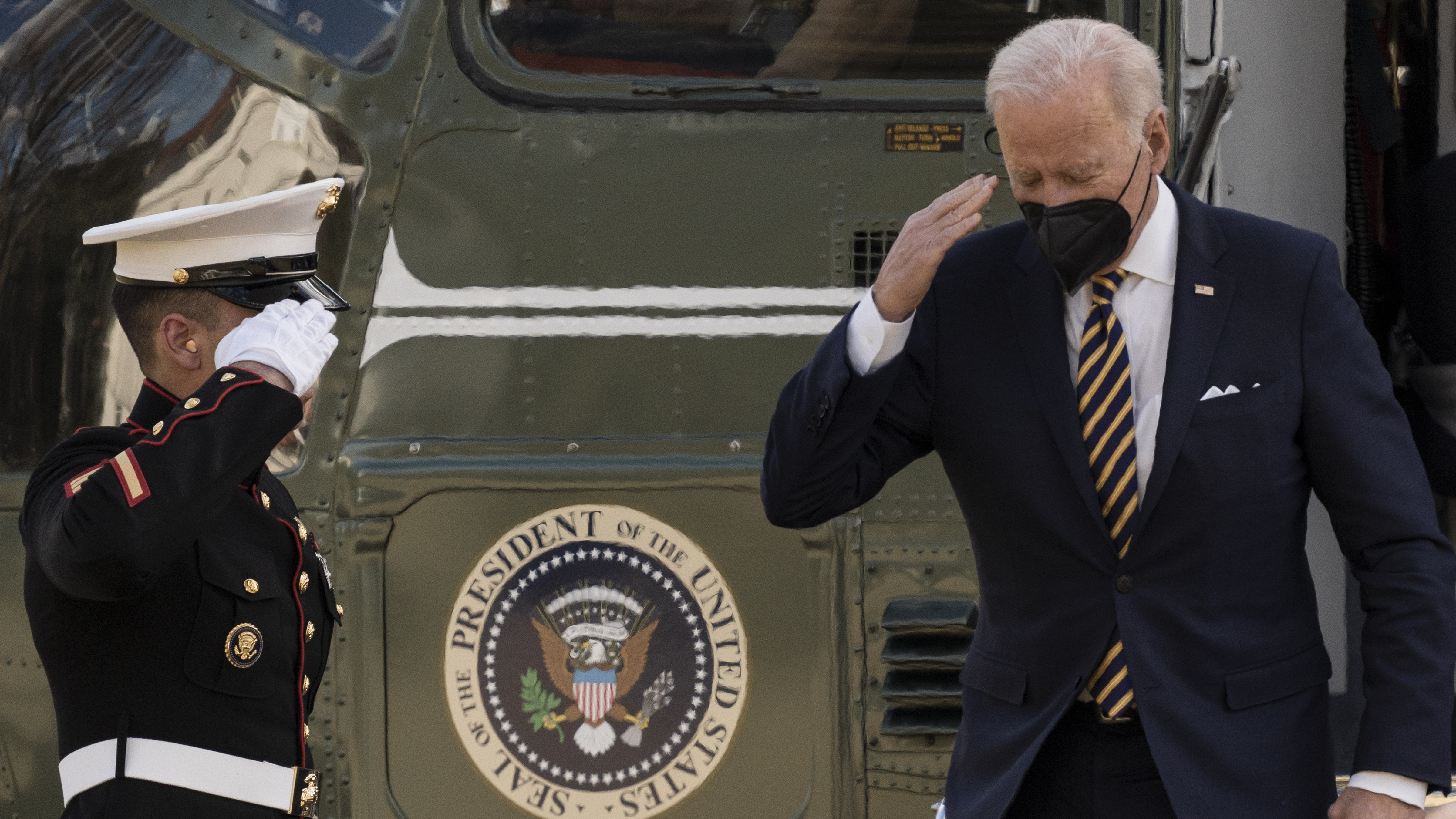Joe Biden salutes after arriving on Marine One on the South Lawn of the White House