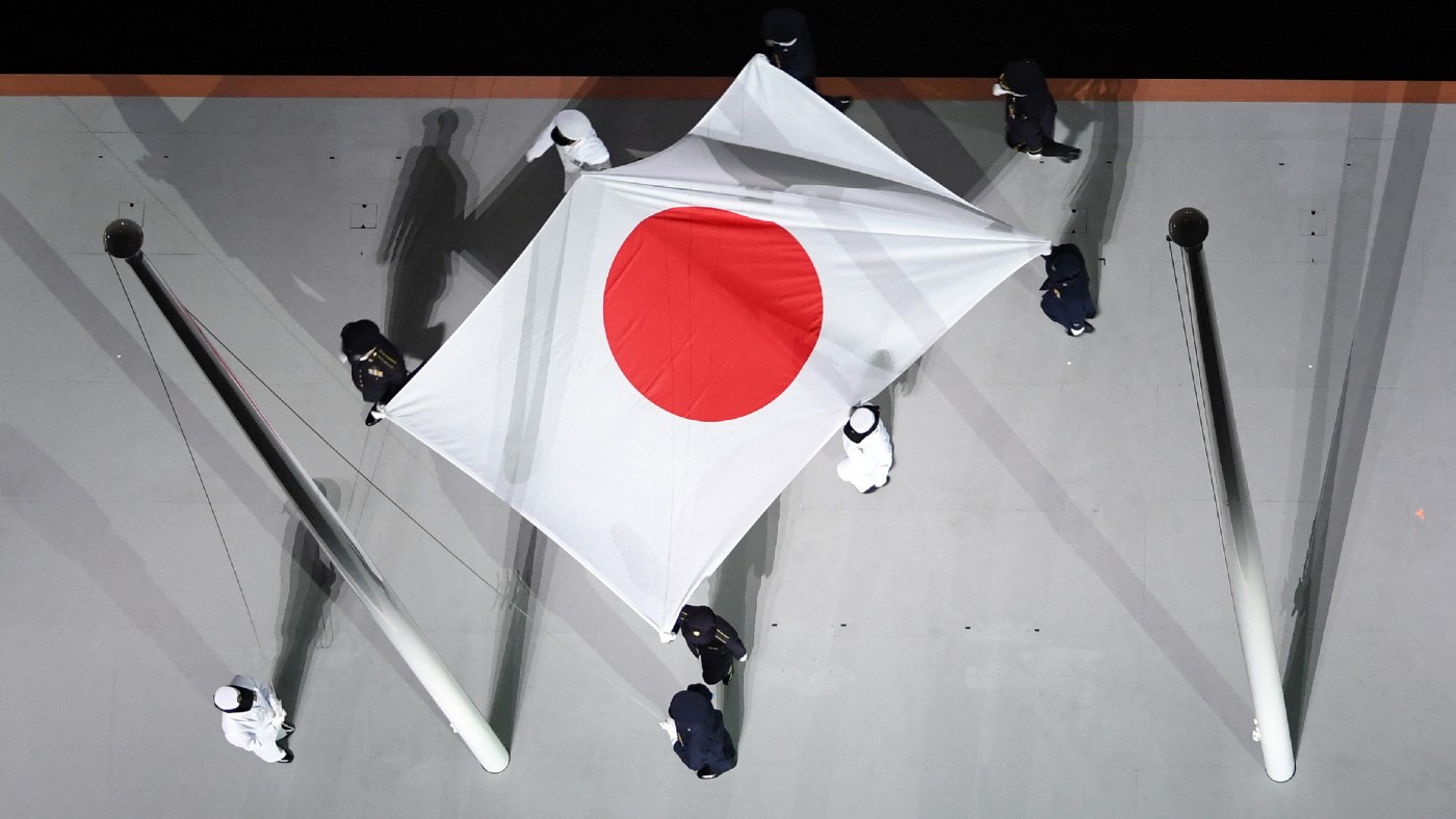 The Japanese national flag is carried onto the stage  