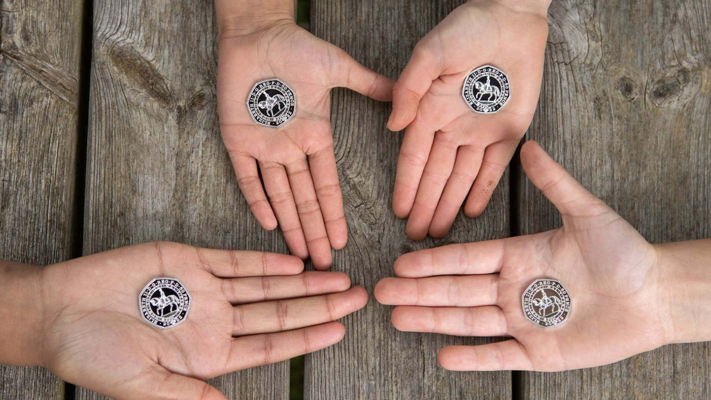 Hands hold new 50p coins