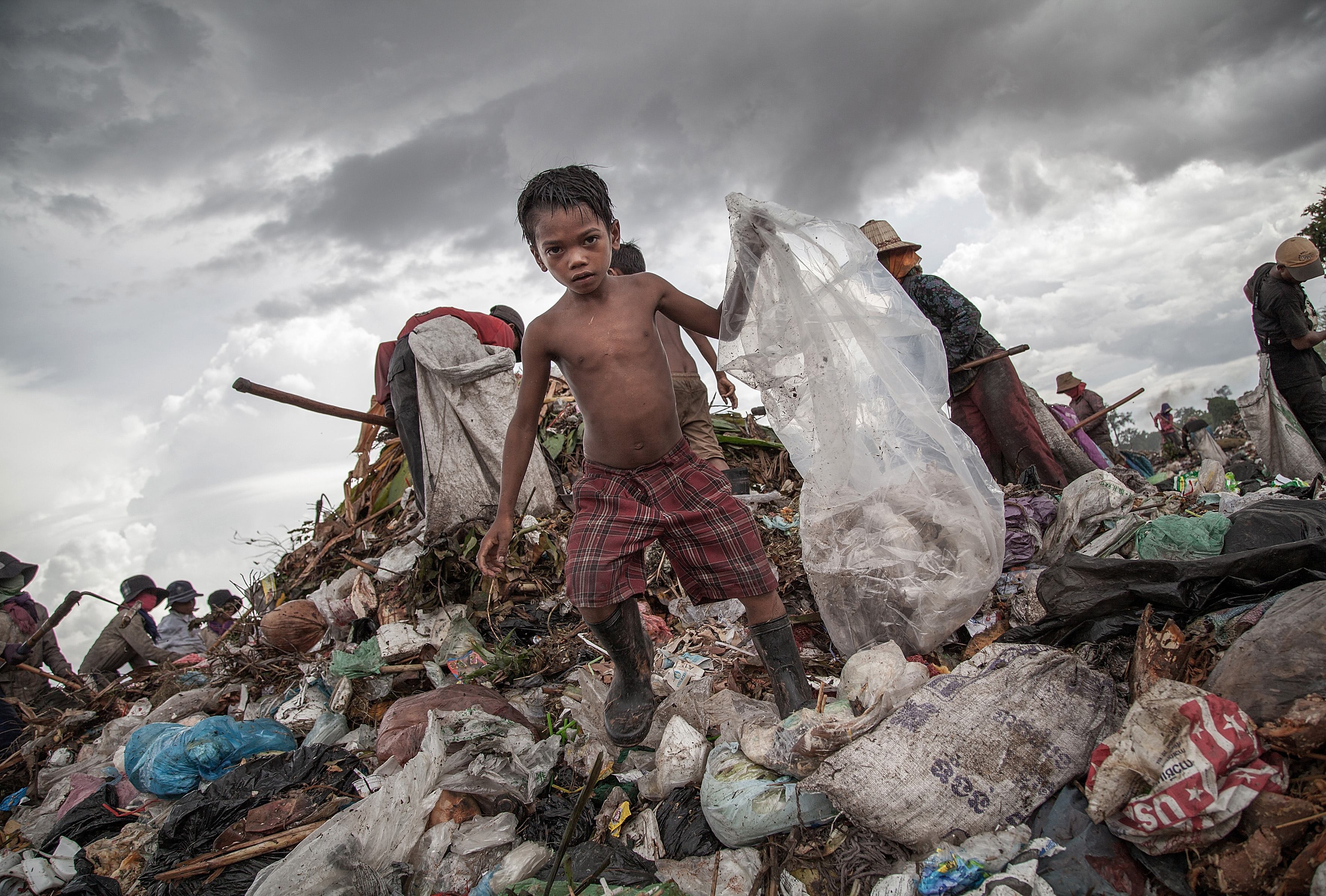 A young boy collects plastic from a landfill in Cambodia