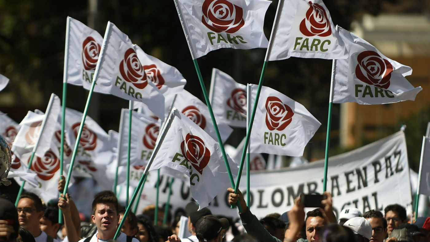 Farc members and supporters wave flags bearing the movement&#039;s new logo at its first conference as a political party