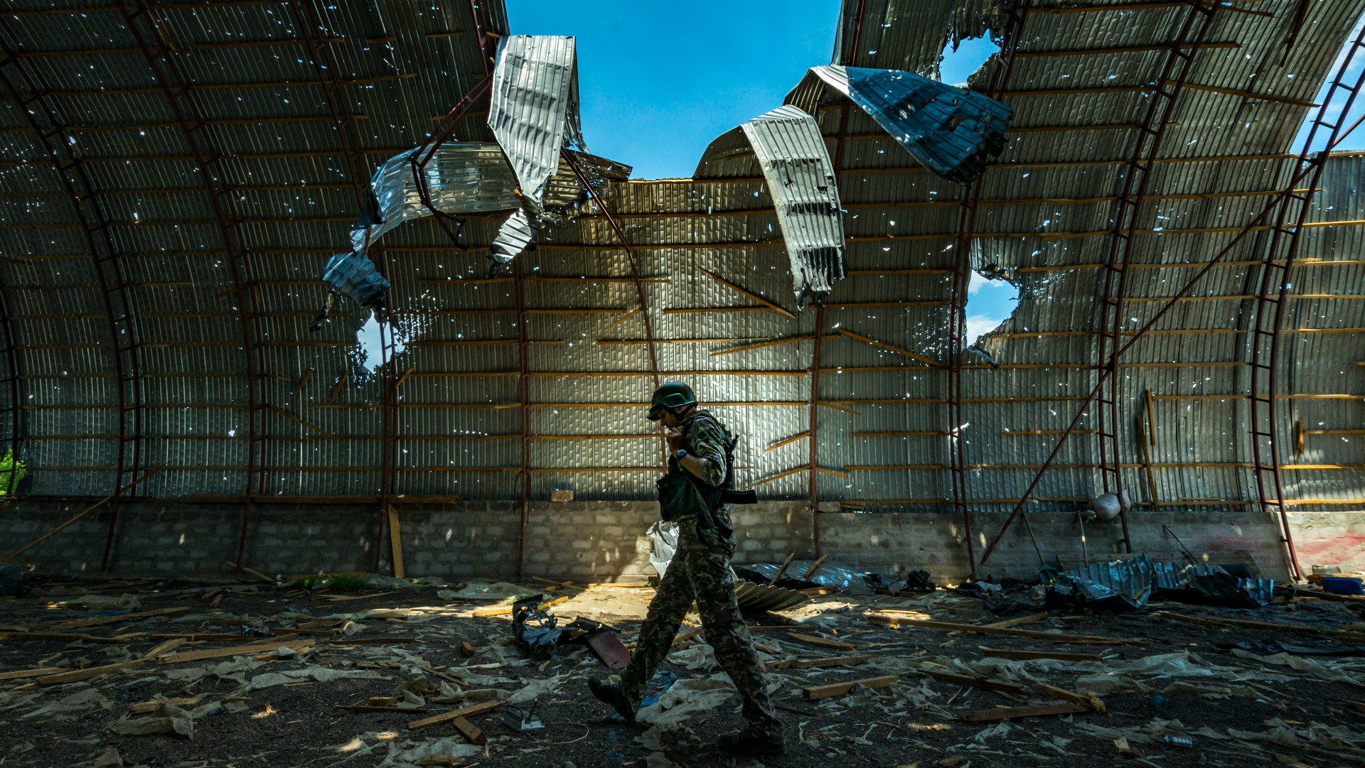A Ukrainian soldier walks through a destroyed barn in Zaporizhzhia