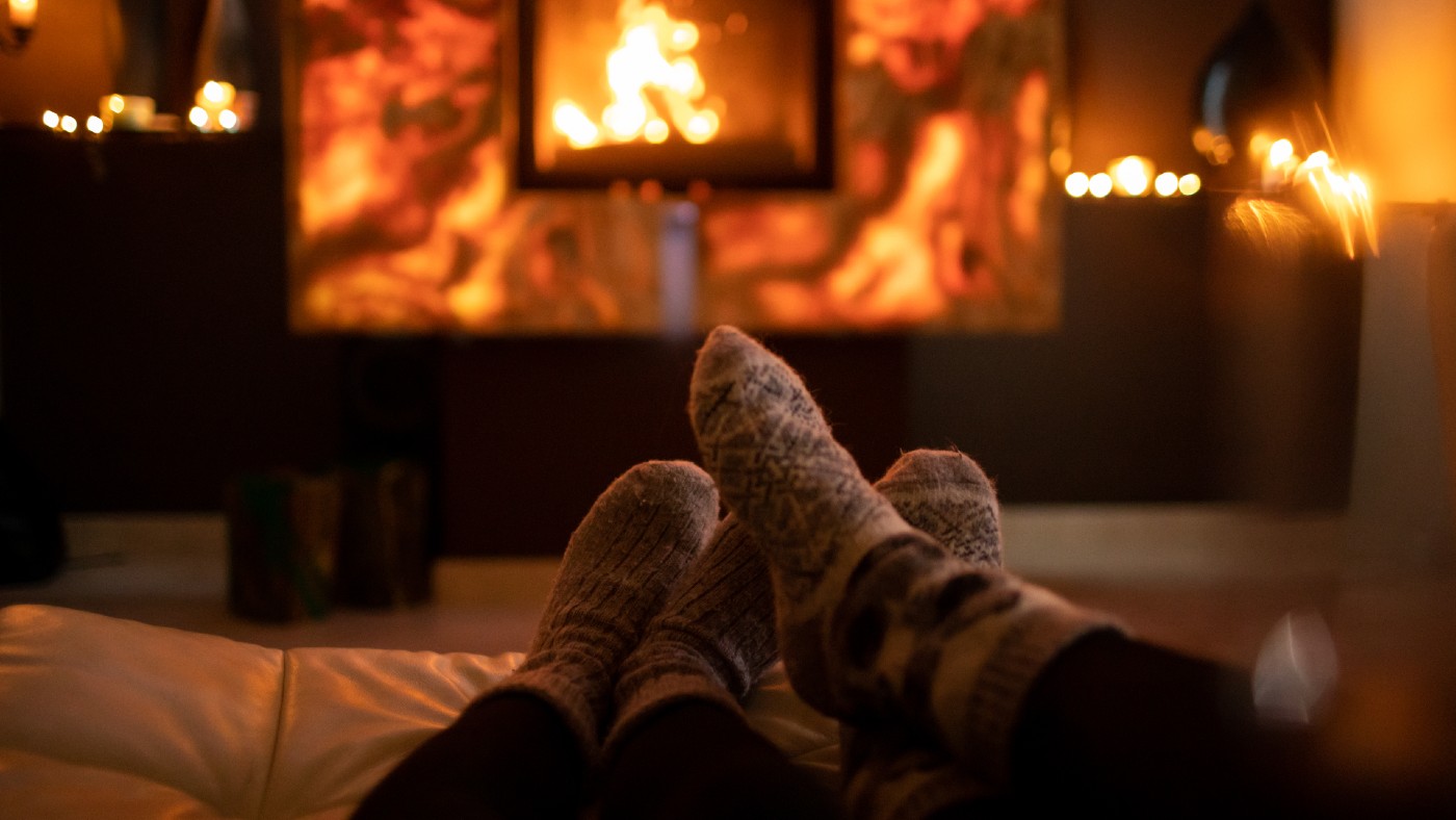 Couple wearing cosy socks by a fire indoors