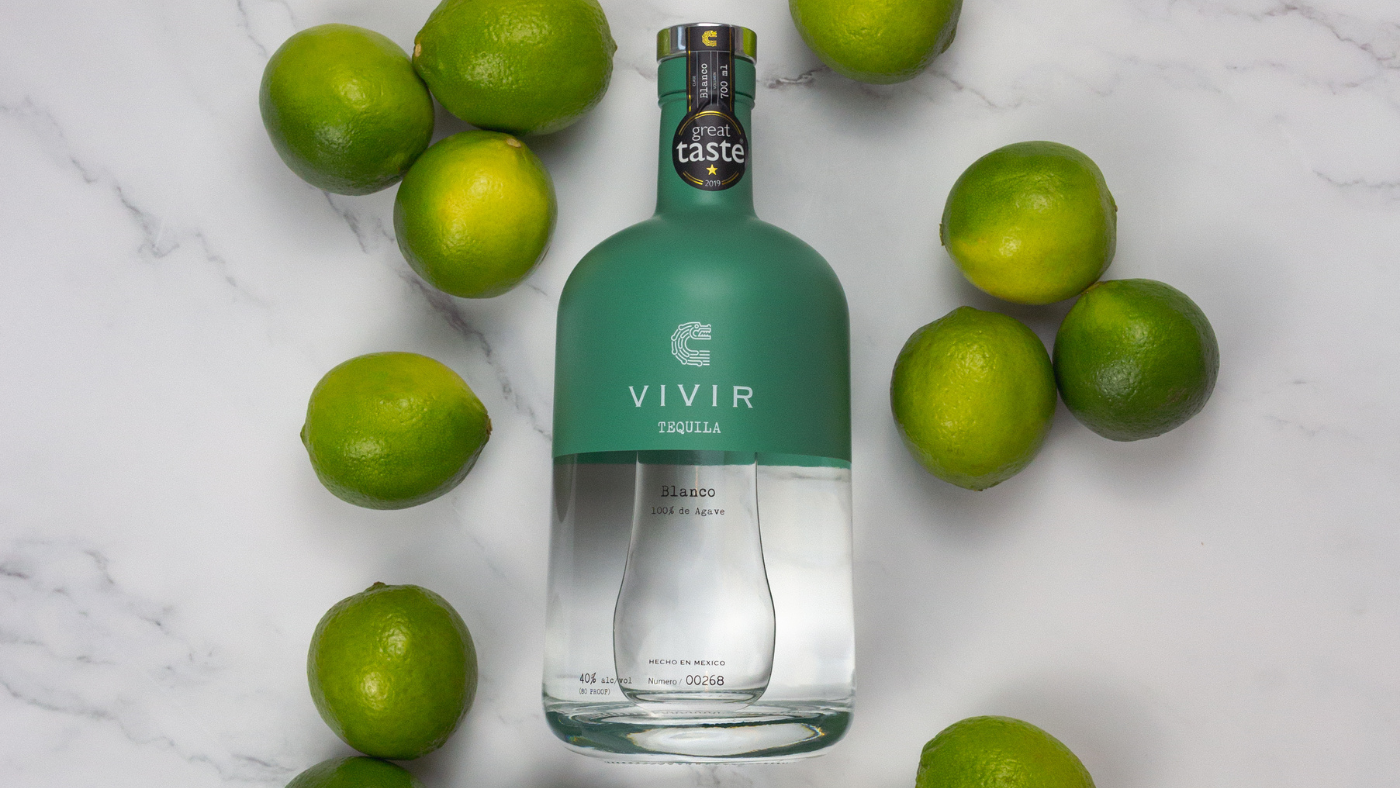 Bottle of VIVIR Blanco surrounded by limes