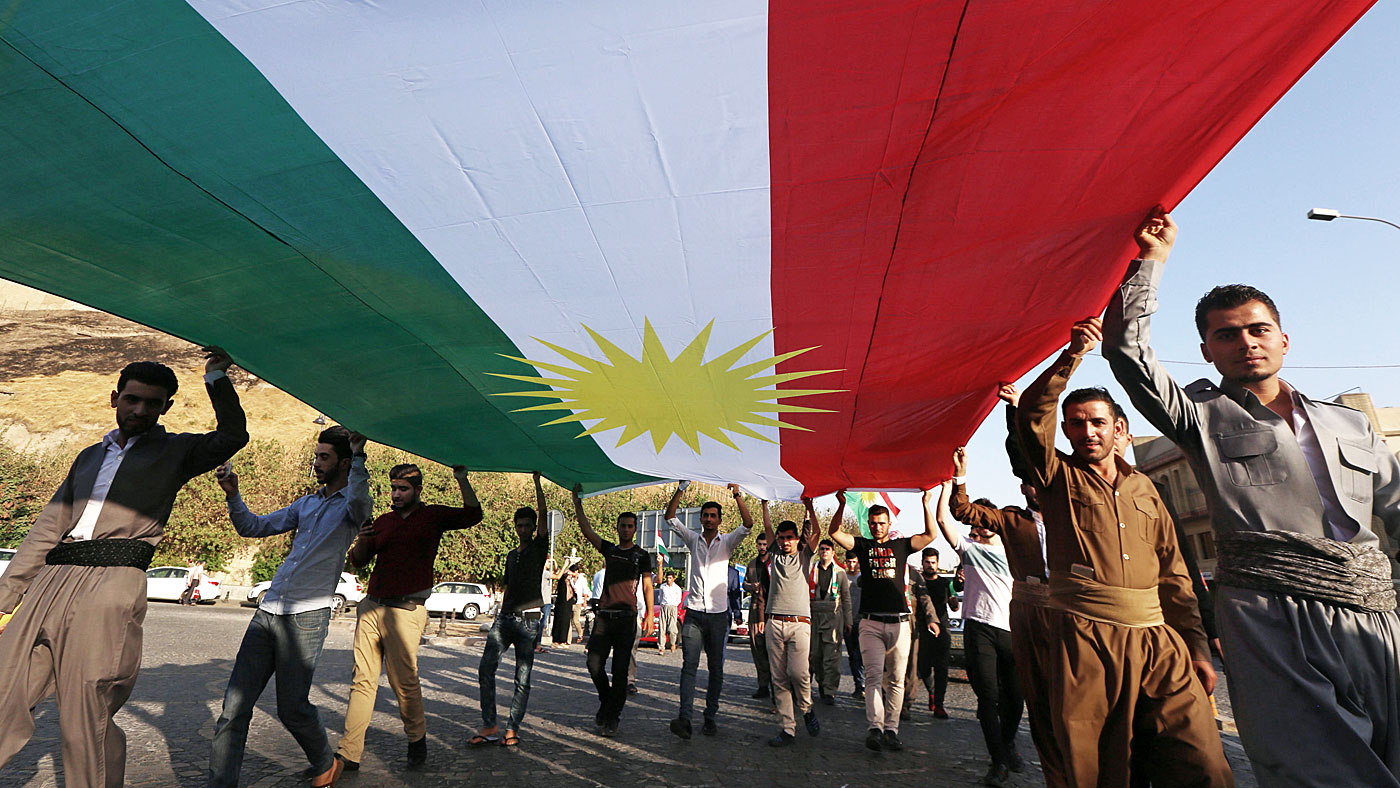 Iraqi Kurds campaigning for independence carry their flag through the streets
