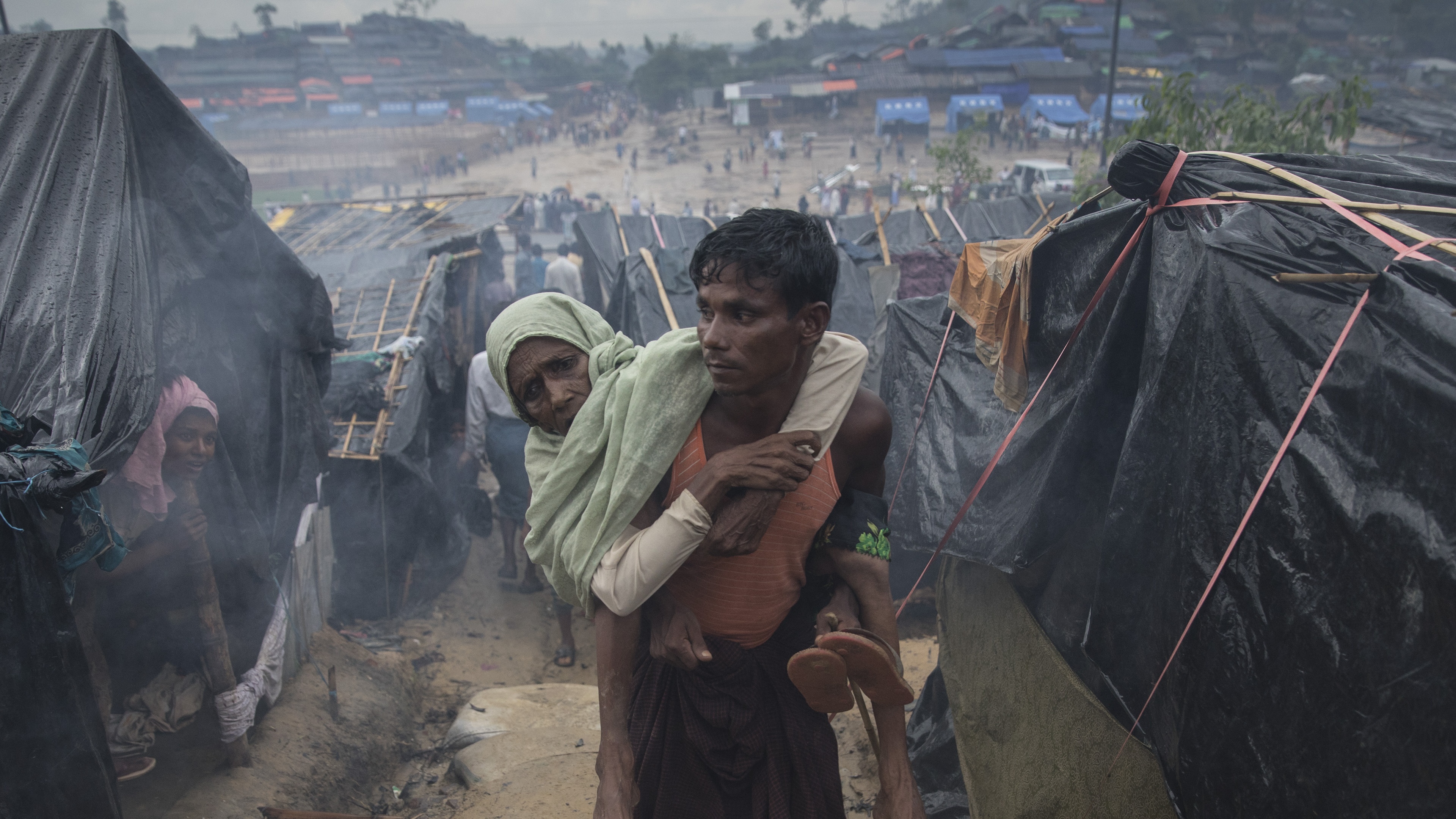 A Rohingya refugee carries his mother in Cox’s Bazar refugee camp, Bangladesh