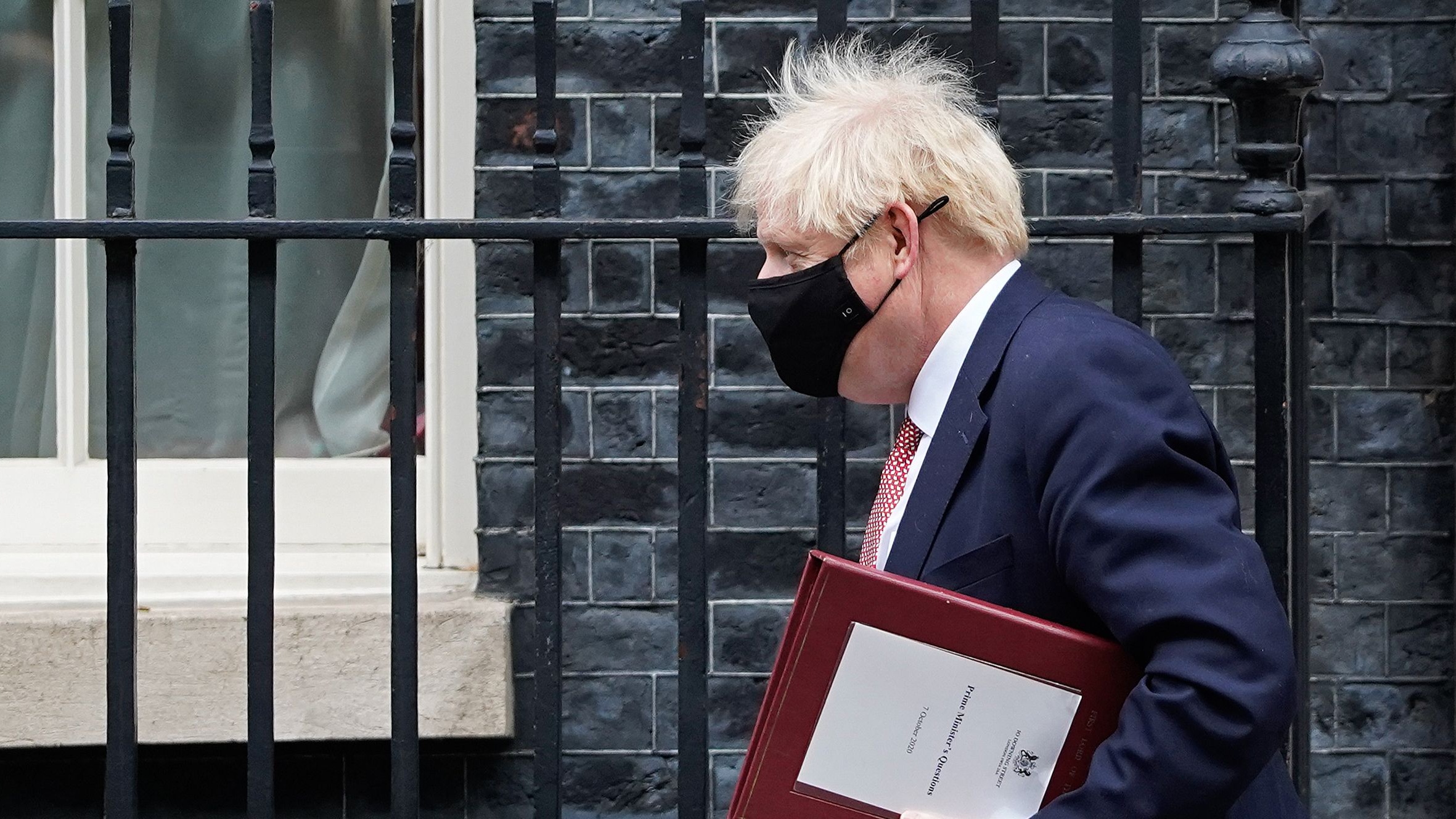 Boris Johnson leaves Downing Street wearing a face mask.