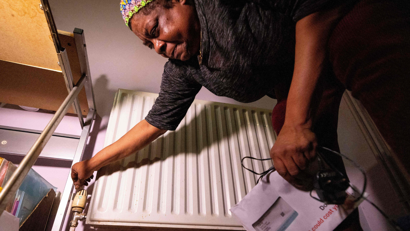 Woman adjusts radiator temperature