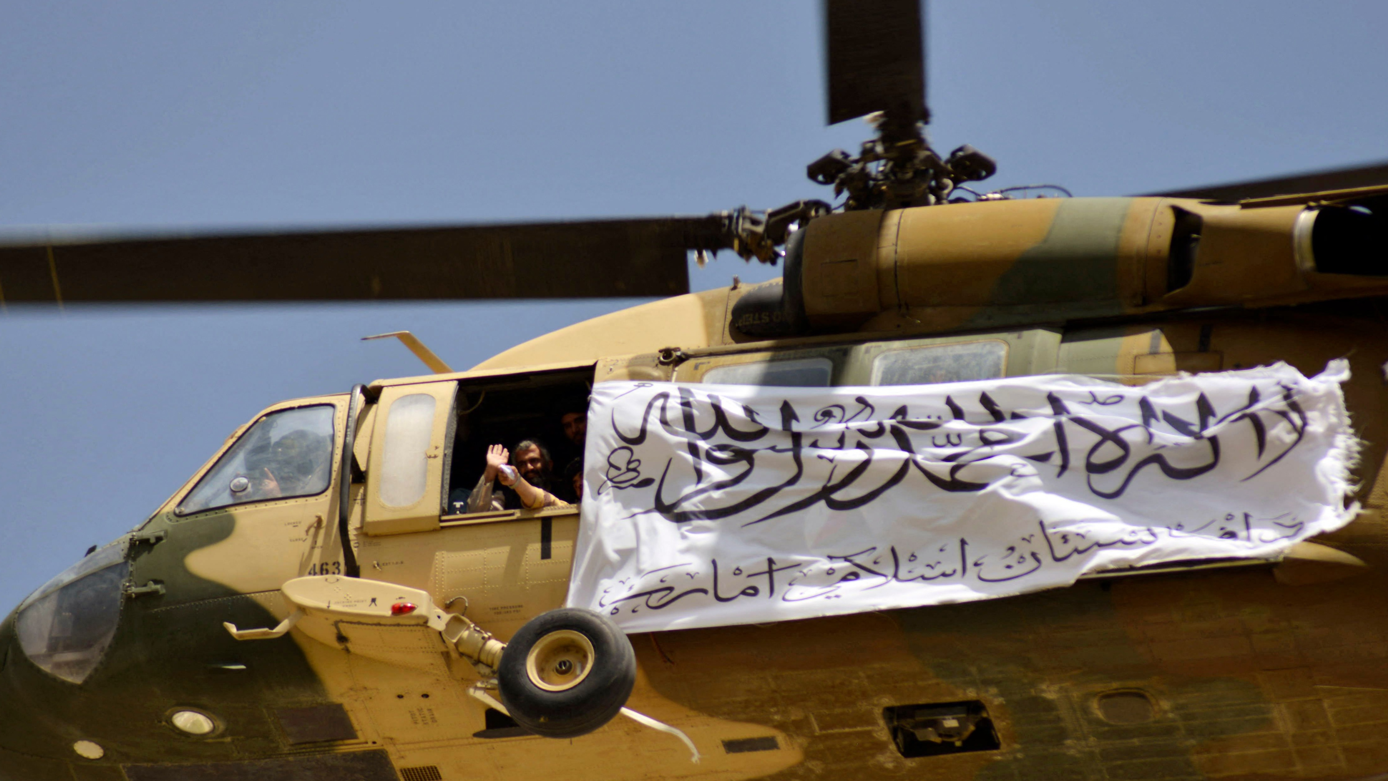 A helicopter flying a Taliban flag above Kandahar