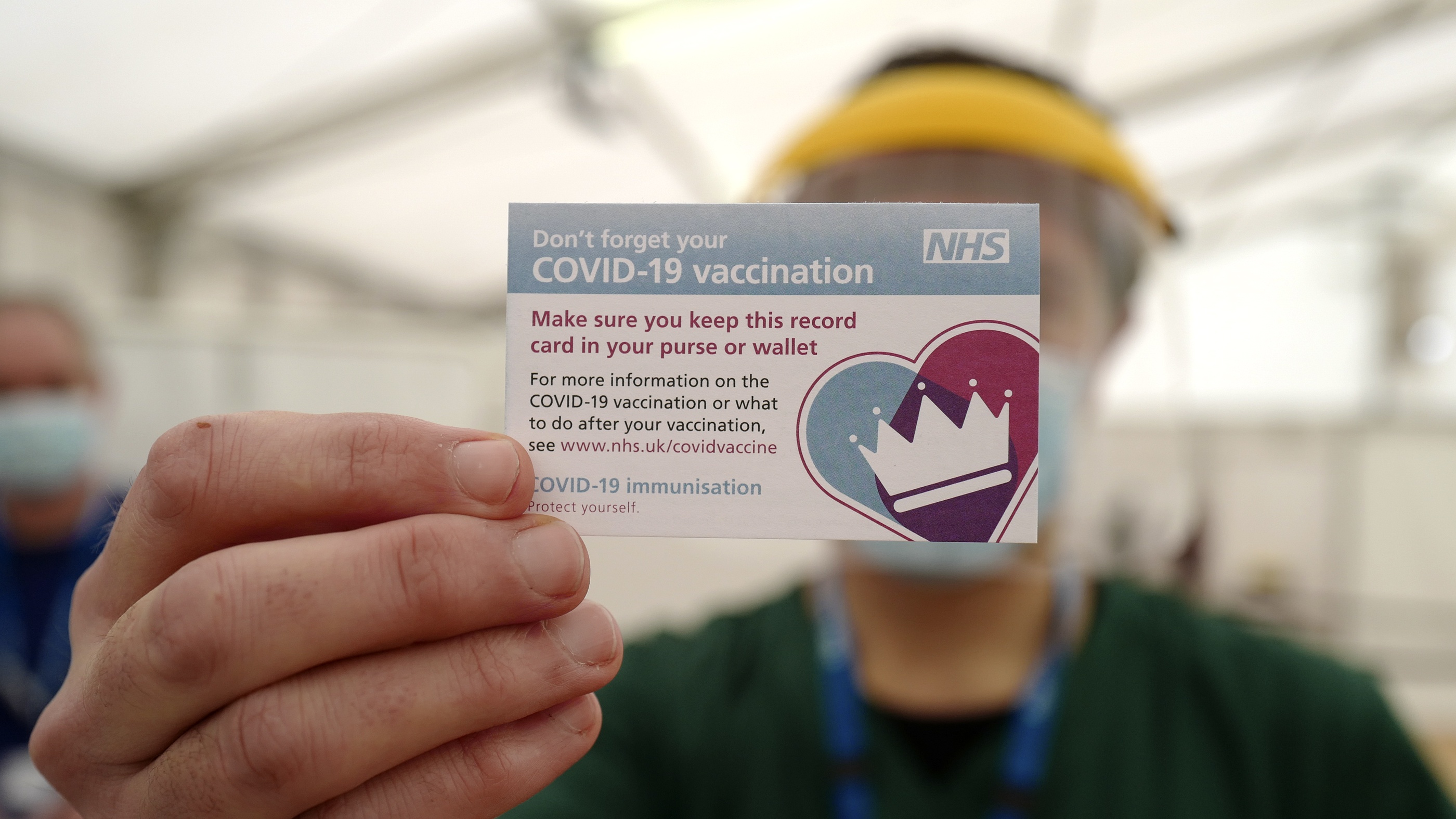 Man shows NHS vaccine card