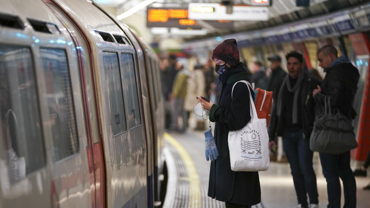 A woman wearing a face mask waits for the tube in London
