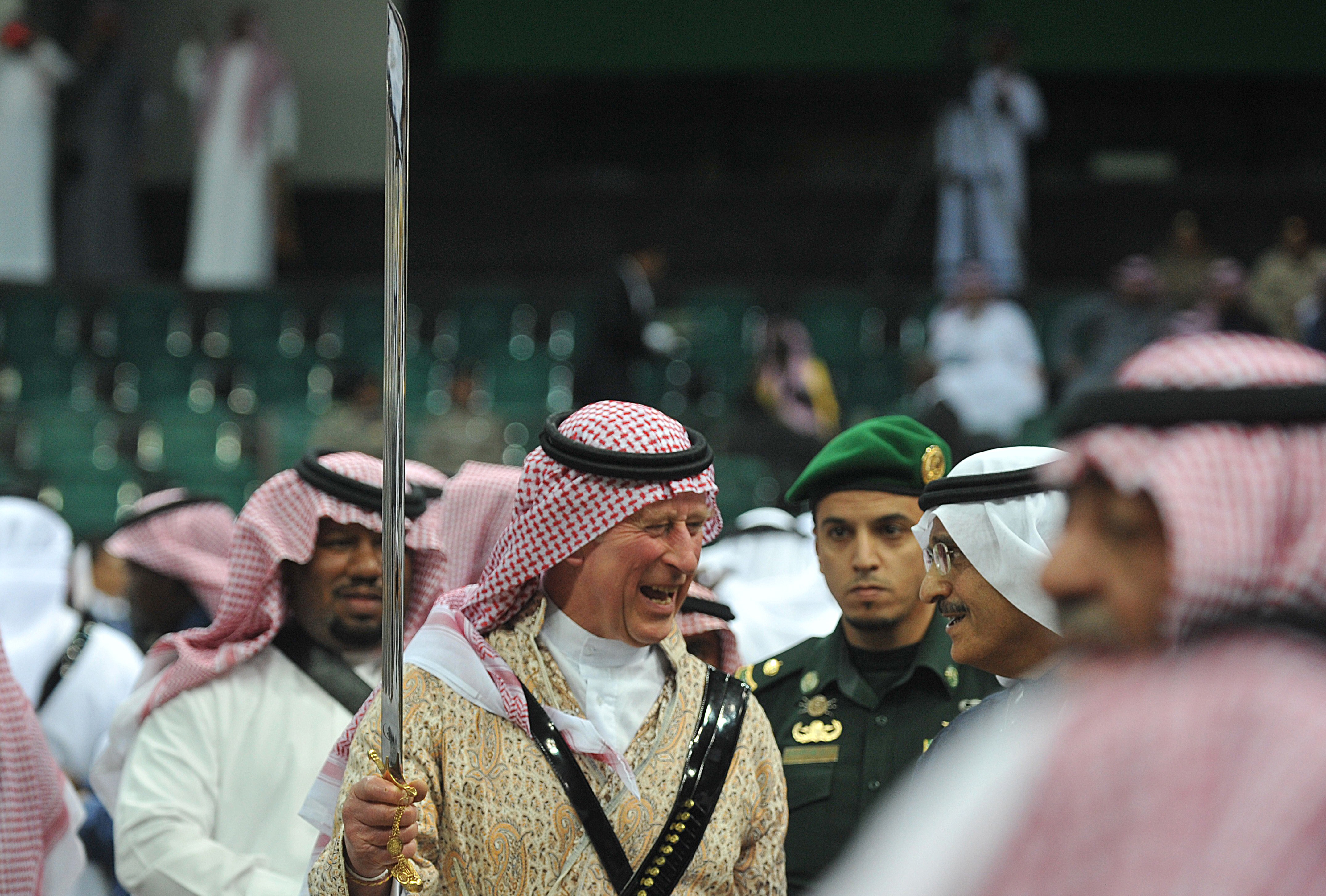 Britain&#039;s Prince Charles (C) wears traditional Saudi uniform as he dances with a sword during the traditional Saudi dancing best known as &#039;Arda&#039; performed during the Janadriya culture festiva