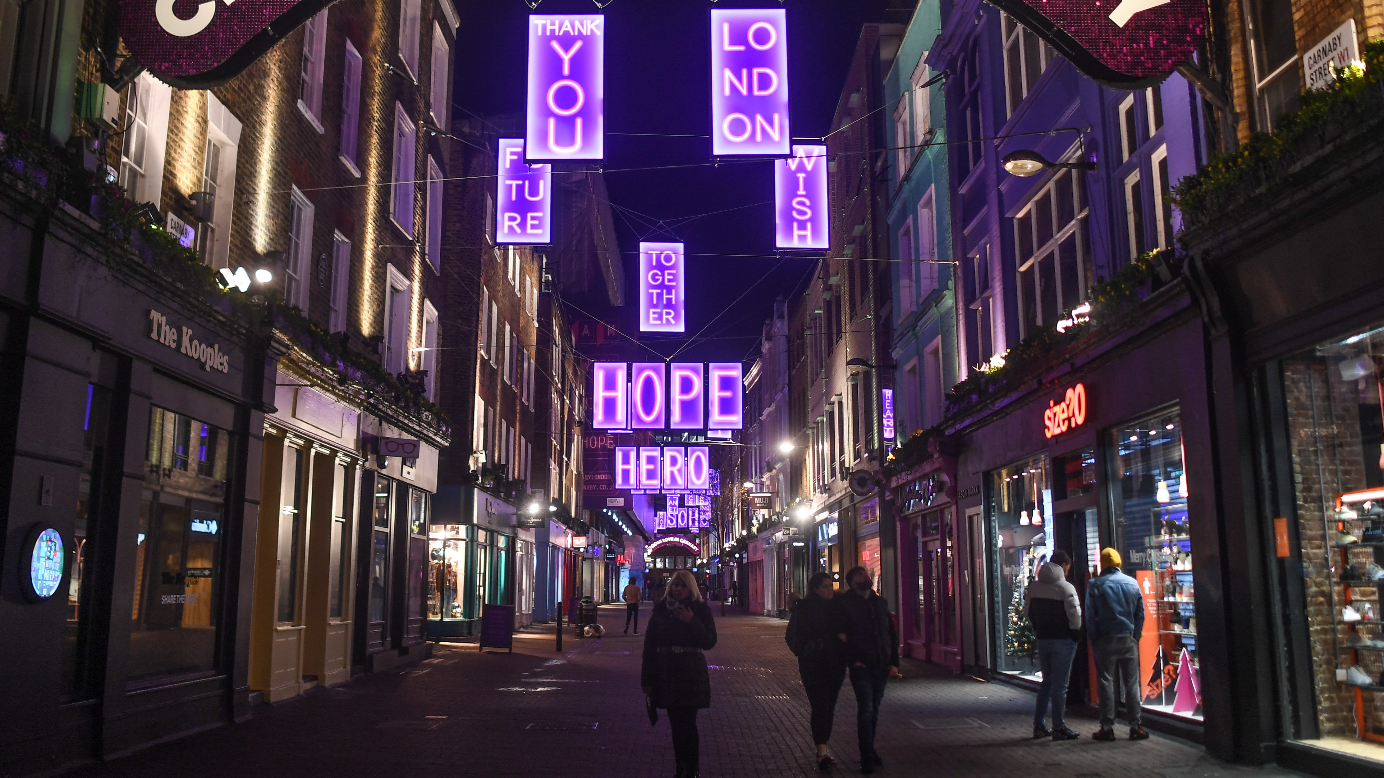 Christmas lights hang over an otherwise quiet Carnaby Street in London