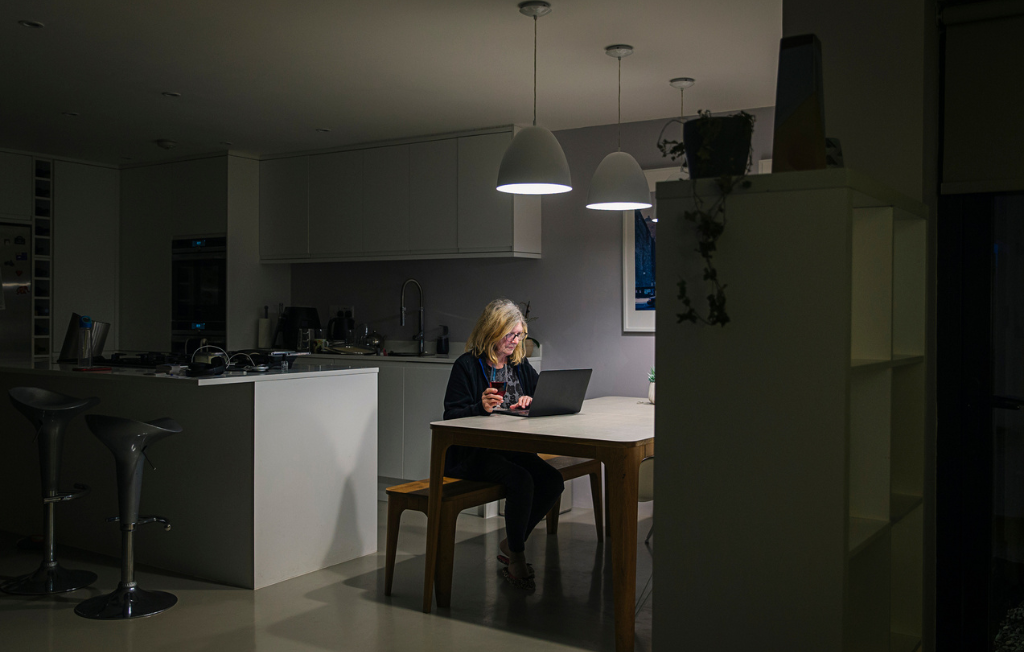 Woman working at laptop at home at night