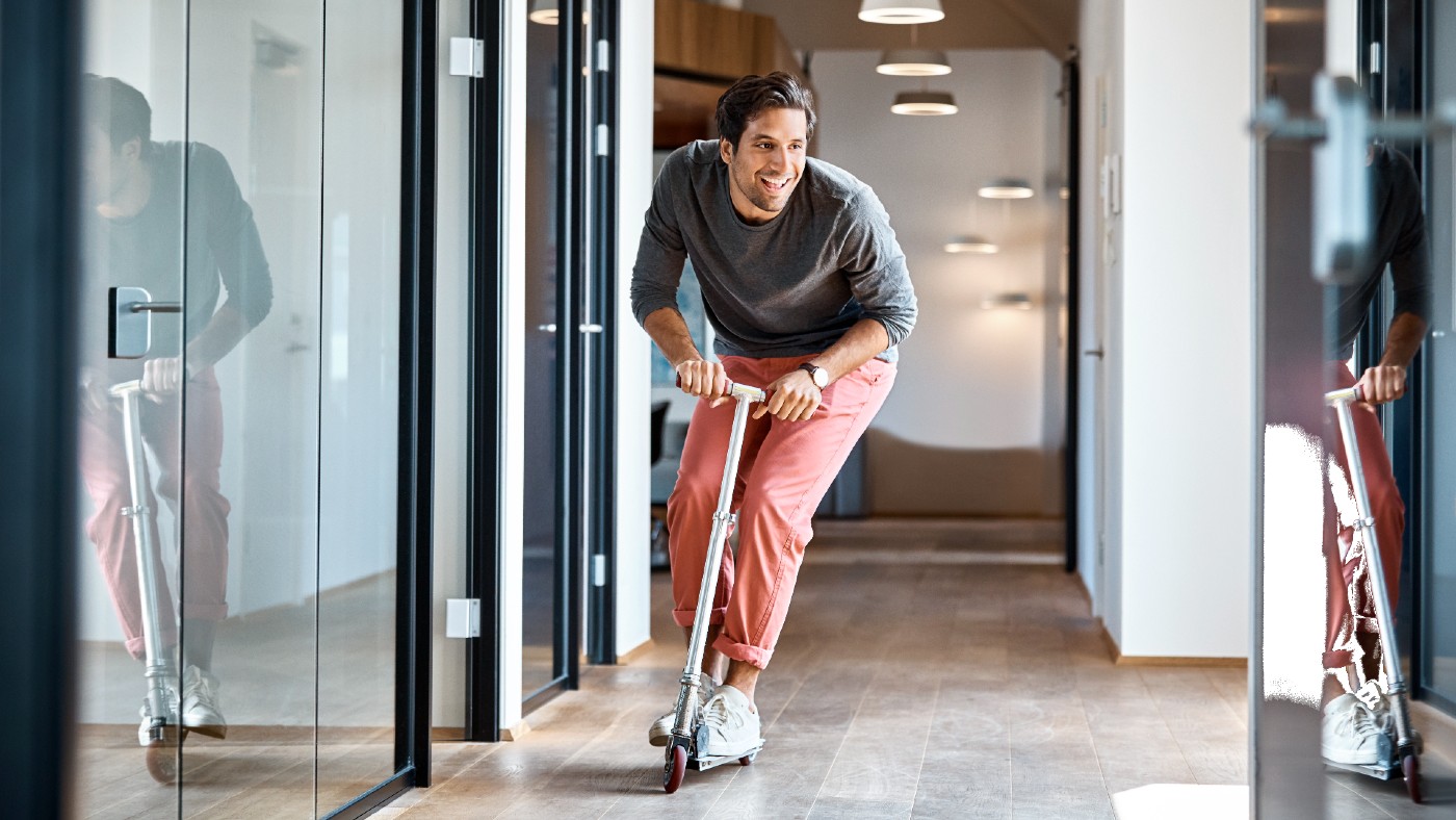 Man riding scooter in an office