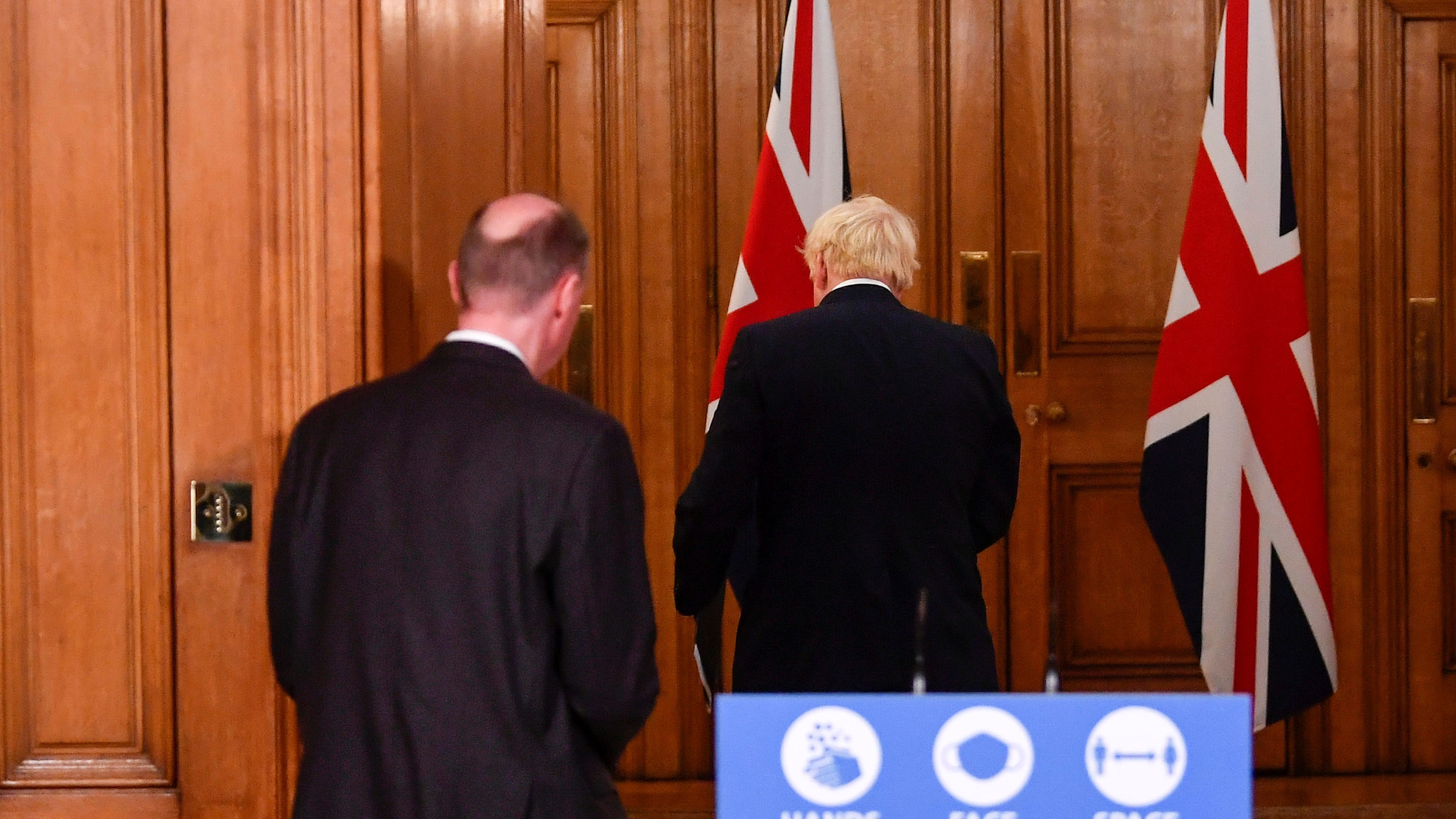 Boris Johnson and Chief Medical Officer Chris Whitty leave a Downing Street press briefing